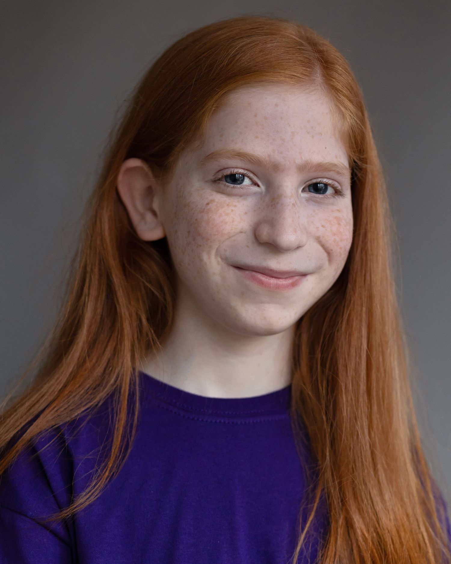 A red-haired boy with long hair captured in an acting headshot, displaying character during a professional headshot session in Manchester