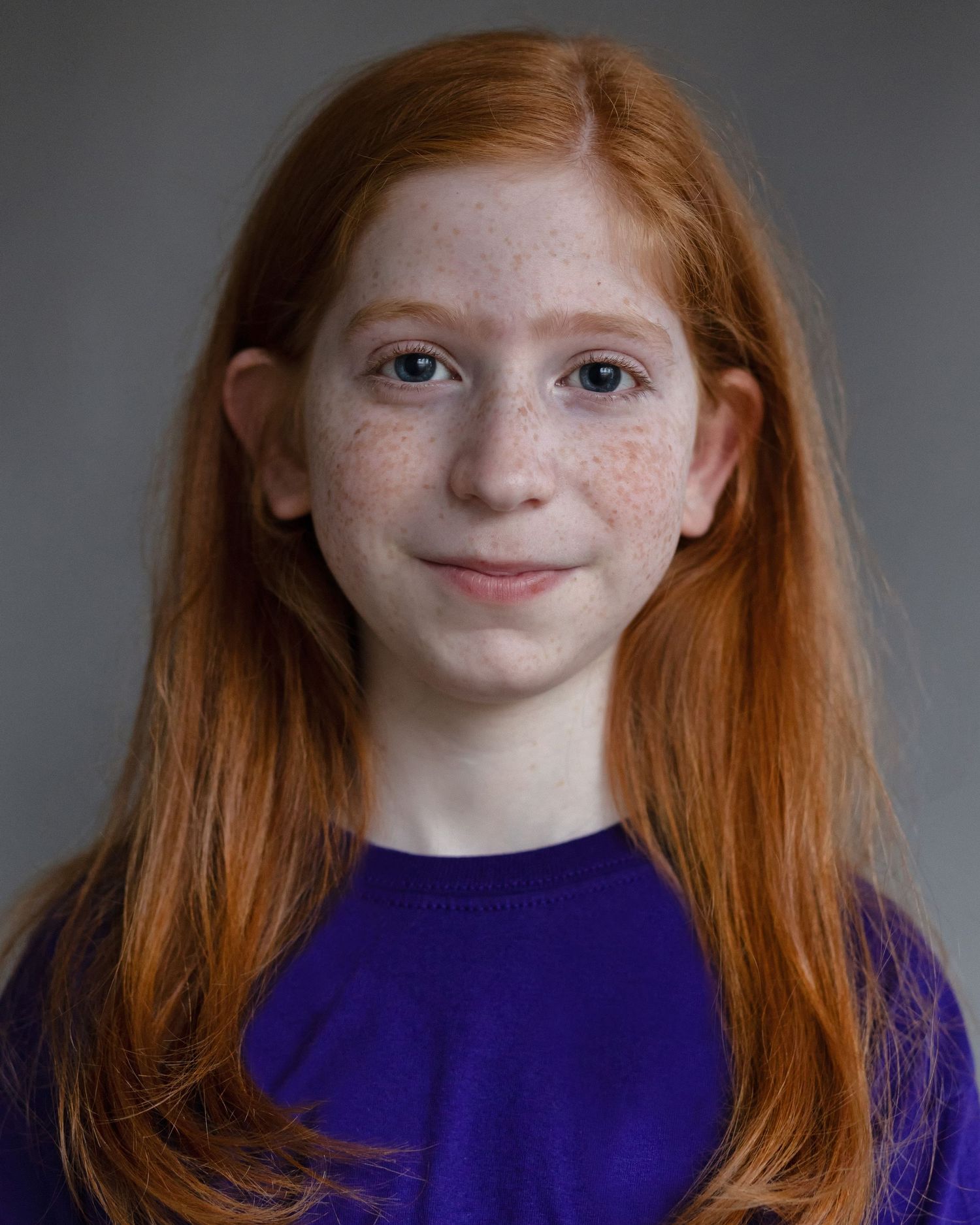 A red-haired boy with long hair posing for an acting headshot, showcasing confidence during a professional headshot session in Manchester
