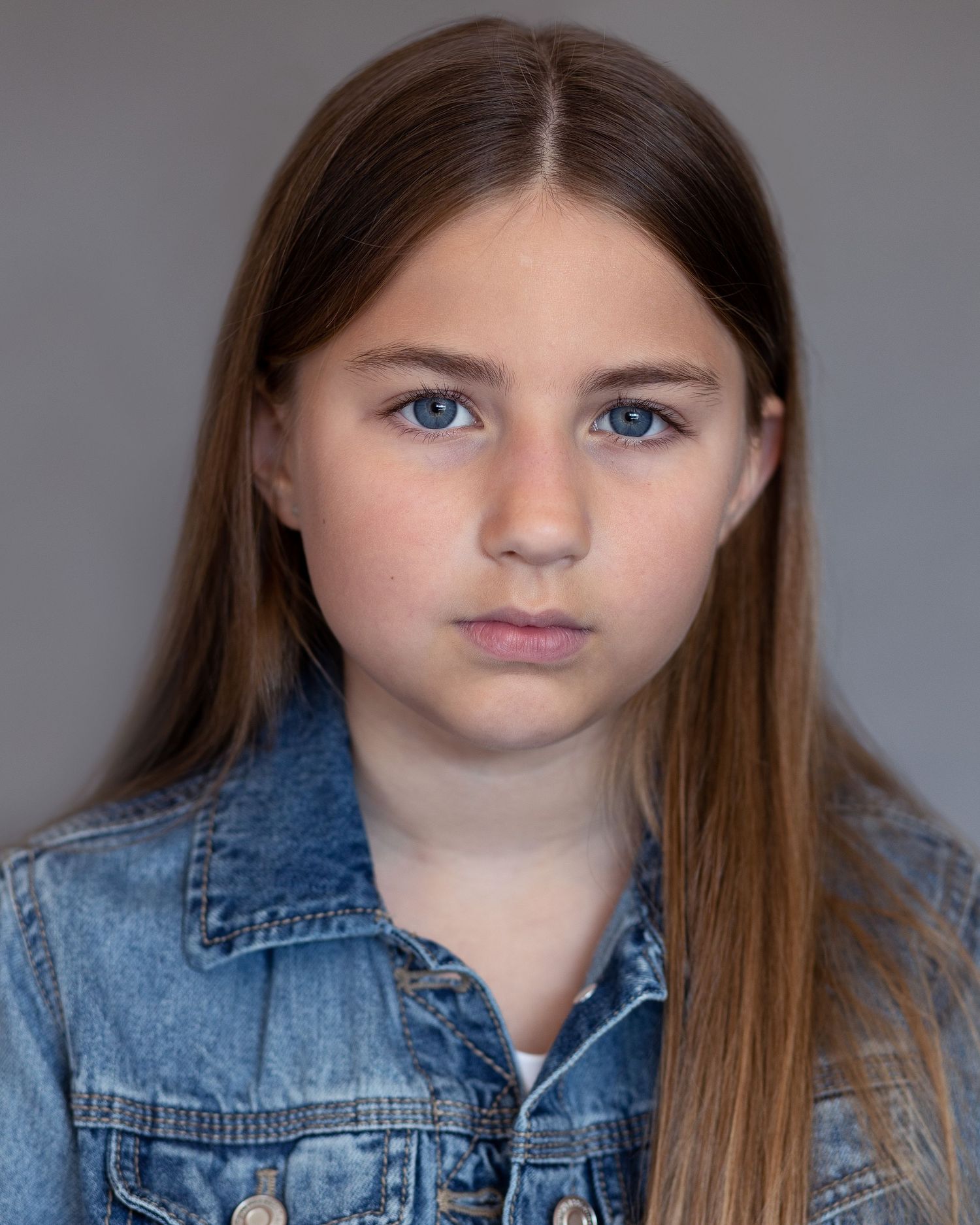A young girl with long hair captured for an acting headshot in Prestwich, displaying poise and confidence during a professional session