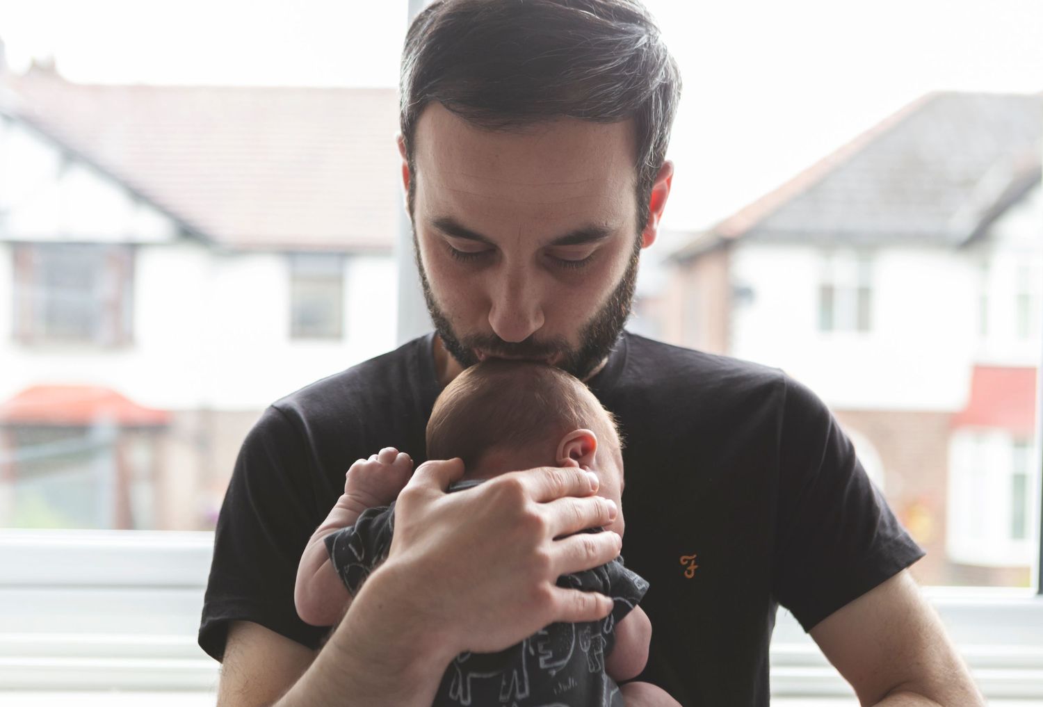 Tender moment between a father and his newborn baby in a cosy nursery room in Prestwich, Manchester.