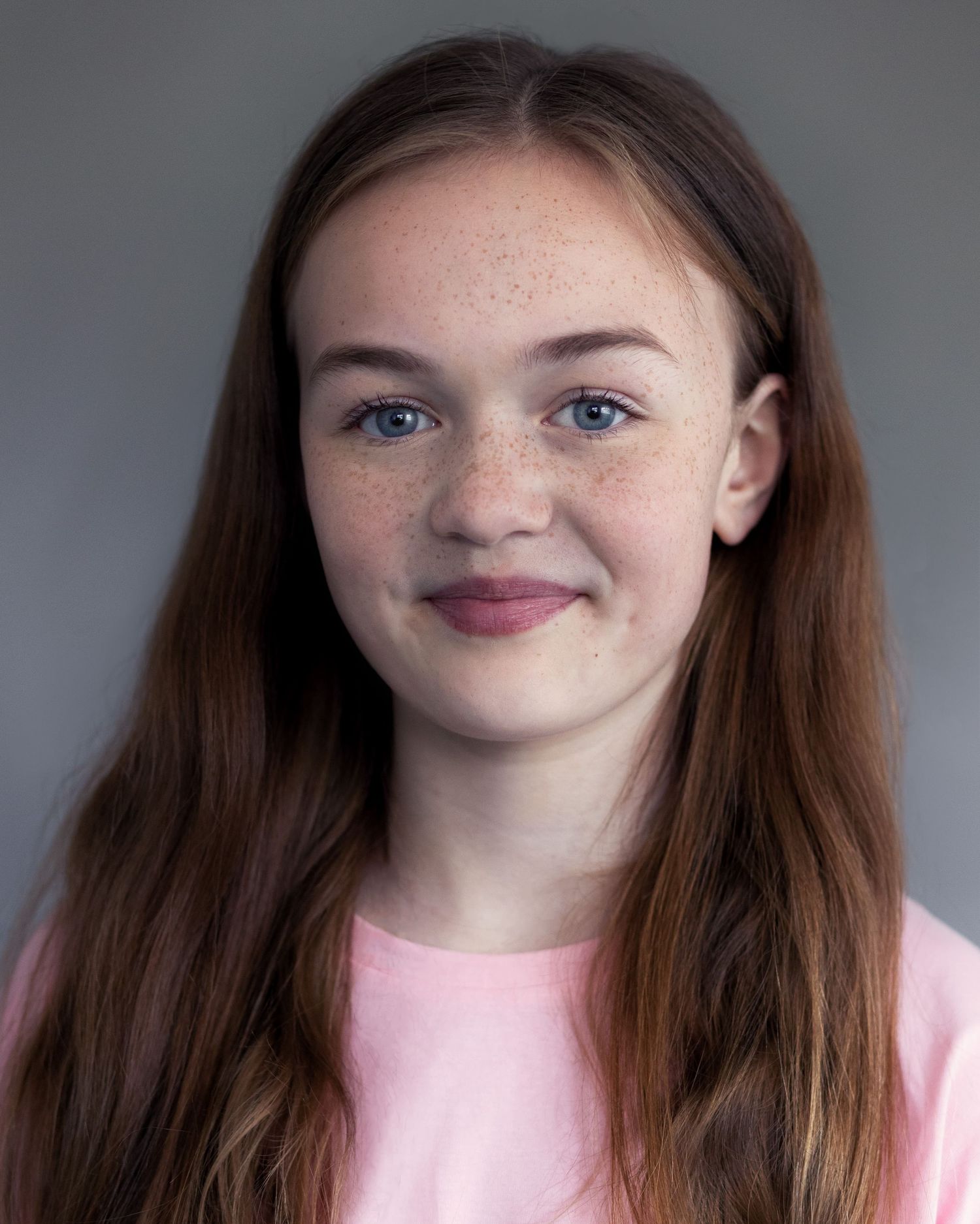 A young girl smiling for an acting headshot in Manchester, exuding confidence and warmth during a professional headshot session