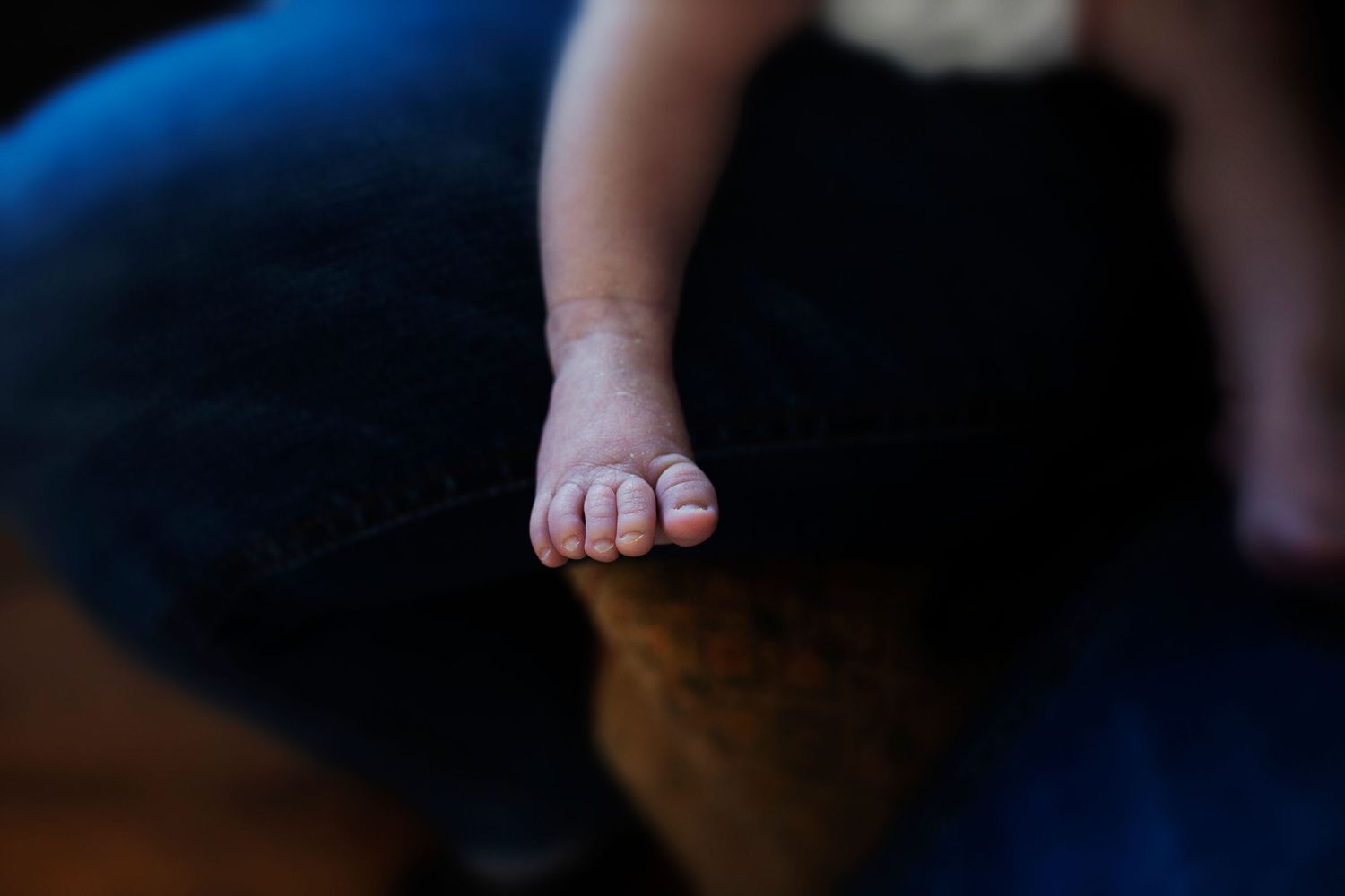 Close-up of a newborn baby’s tiny foot during a cosy at-home photoshoot in Prestwich