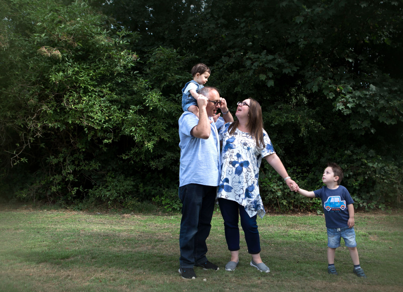 Family of four enjoying a sunny day in a park in Prestwich, Manchester