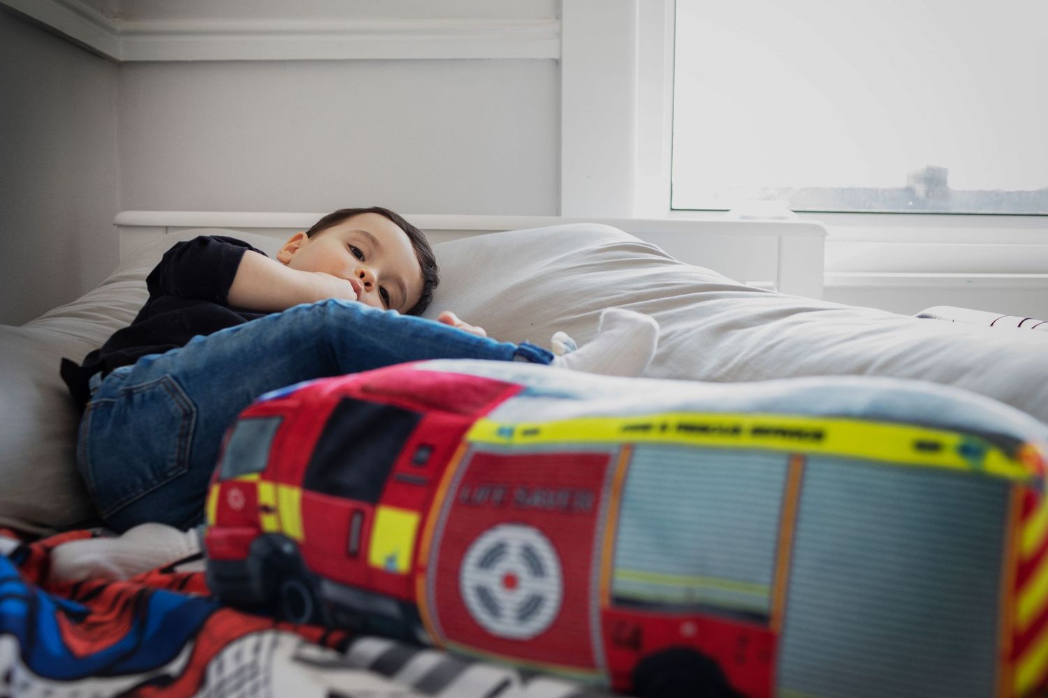 Lifestyle family photo session with young boy lying on his bed at his home in Manchester