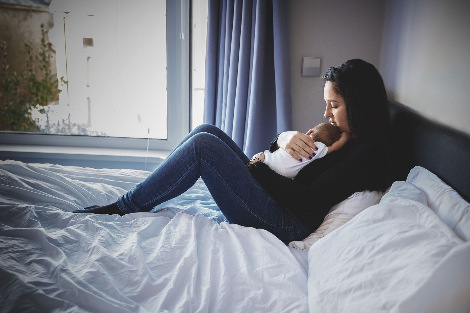 Mother sharing a quiet, intimate moment with her newborn baby at home in Prestwich, Manchester