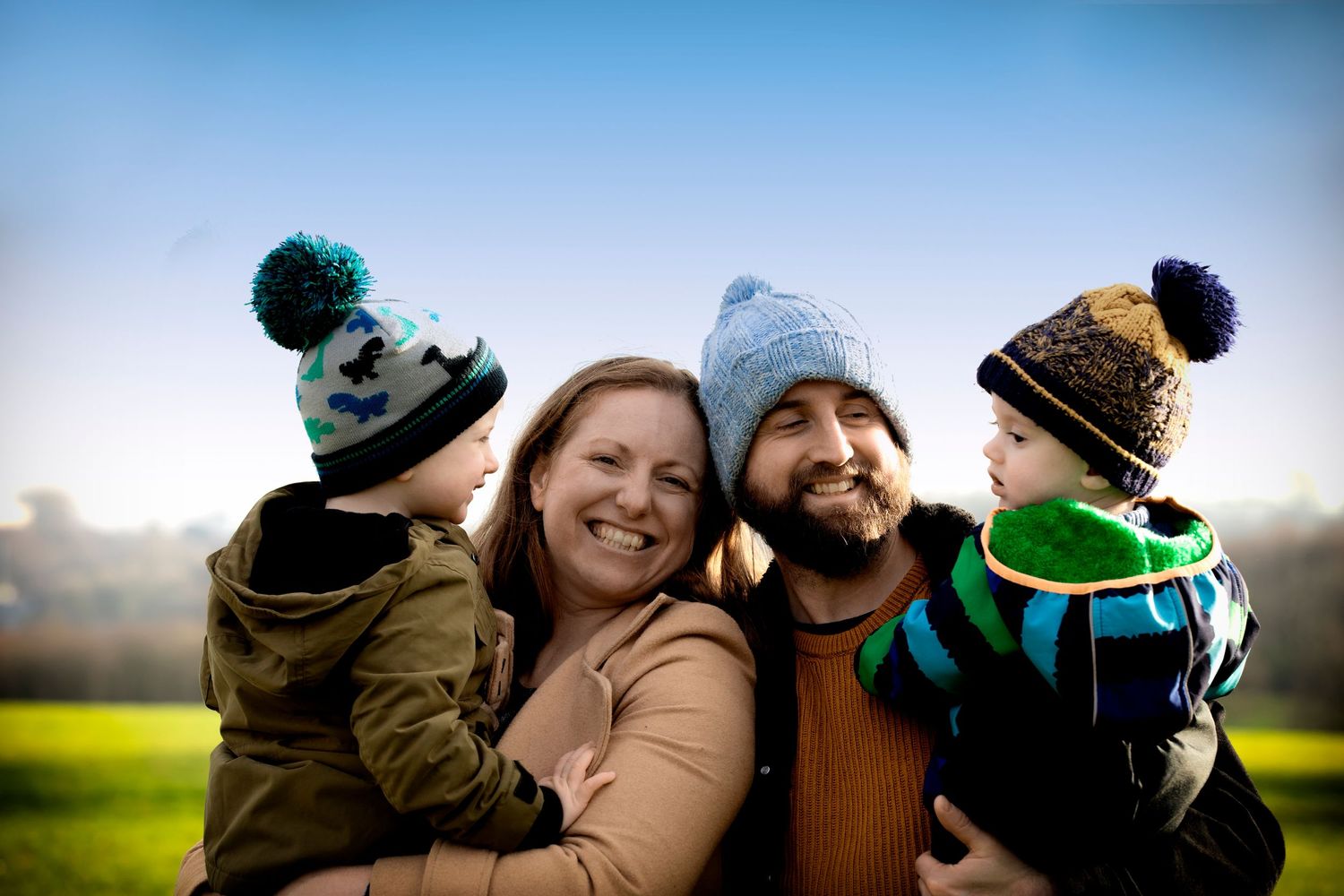 Family of four laughing together in a beautiful outdoor location in Bury, Manchester