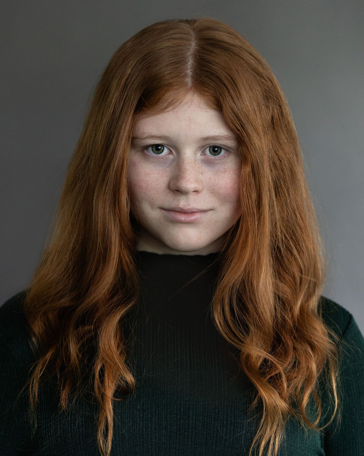 A captivating red-haired girl with strong eye contact for an acting headshot, exuding confidence during a professional session in Prestwich