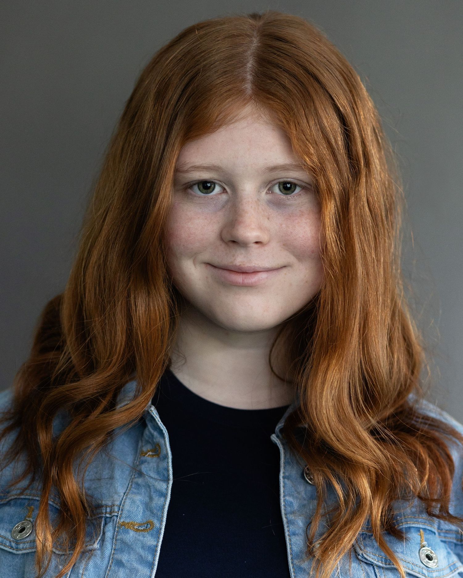 A red-haired girl posing for an acting headshot, looking confident during a professional headshot session in Prestwich, Manchester