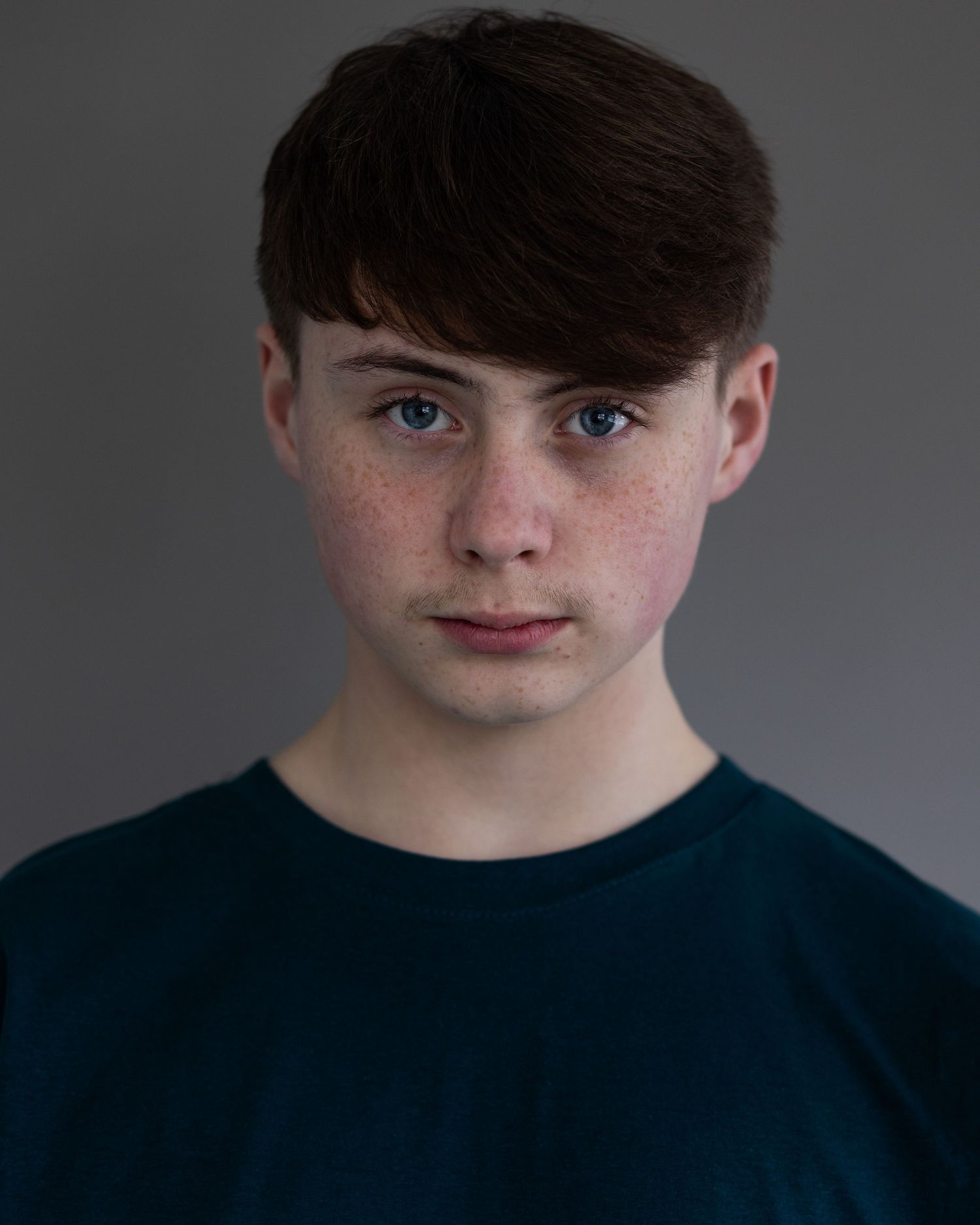 Dark haired boy posing for an acting headshot, looking confident and focused during a professional headshot session in Prestwich, Manchester