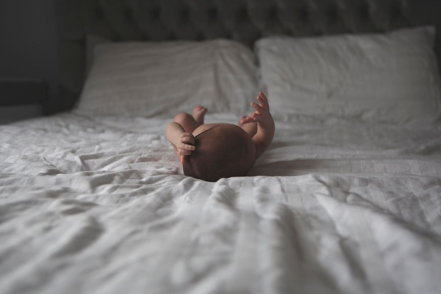 Newborn baby lying on the bed in the comfort of family home in Prestwich, Manchester.