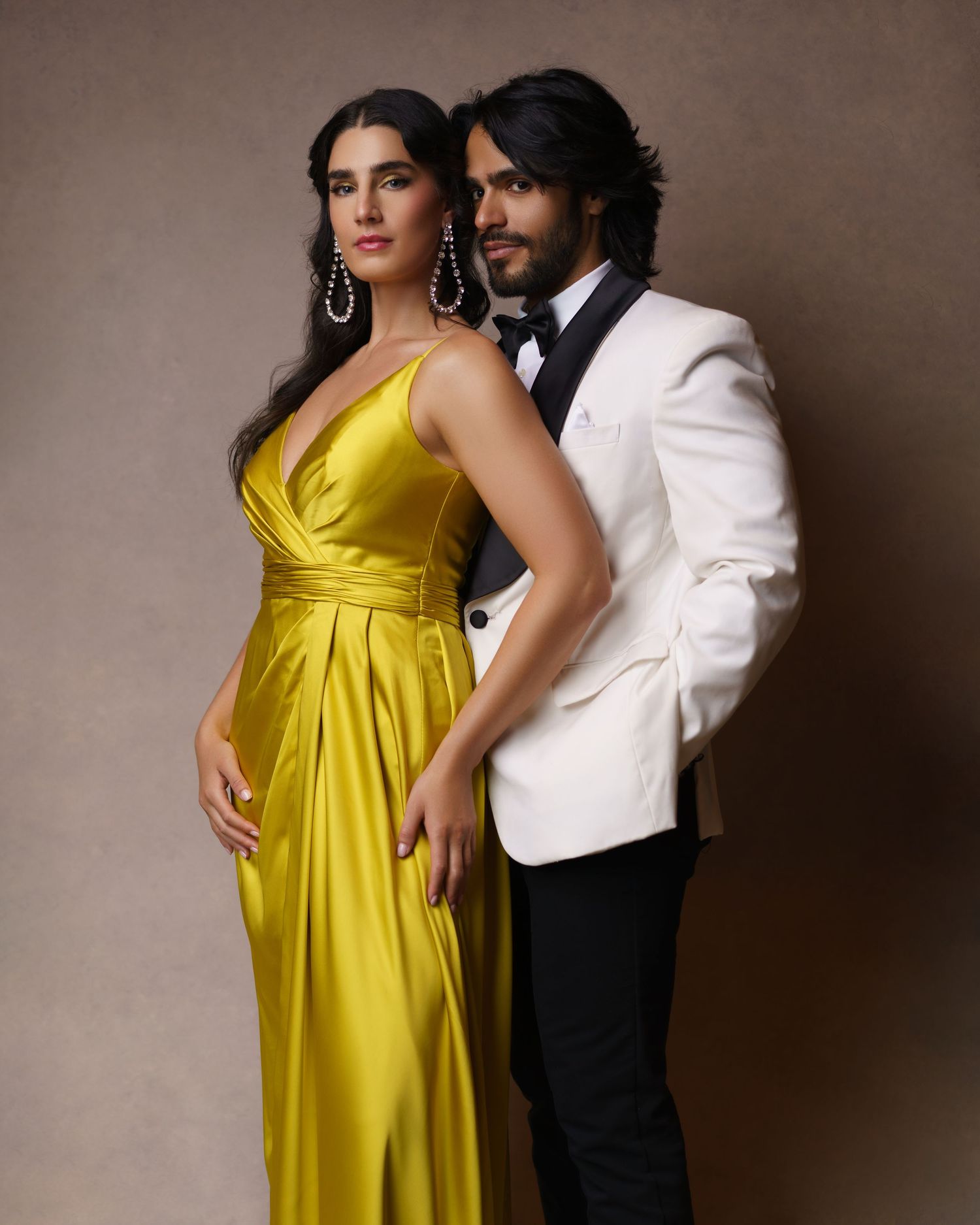 Stylish couple posing in a tuxedo and luxurious evening gown — a romantic couple’s love story captured in studio in Chicago.