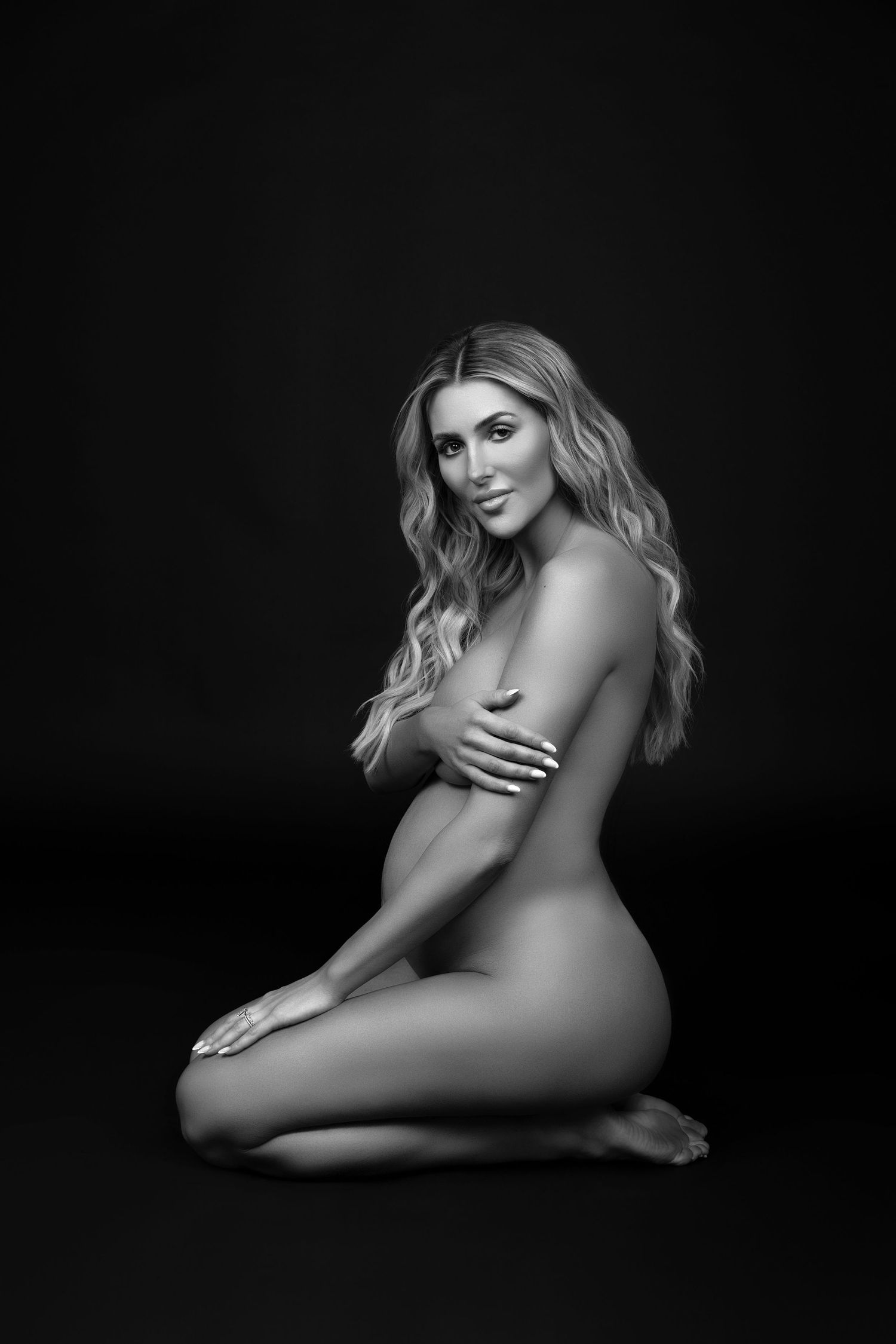 Striking black-and-white nude portrait of a blonde pregnant woman — graceful and refined pose captured in a fine art maternity session.