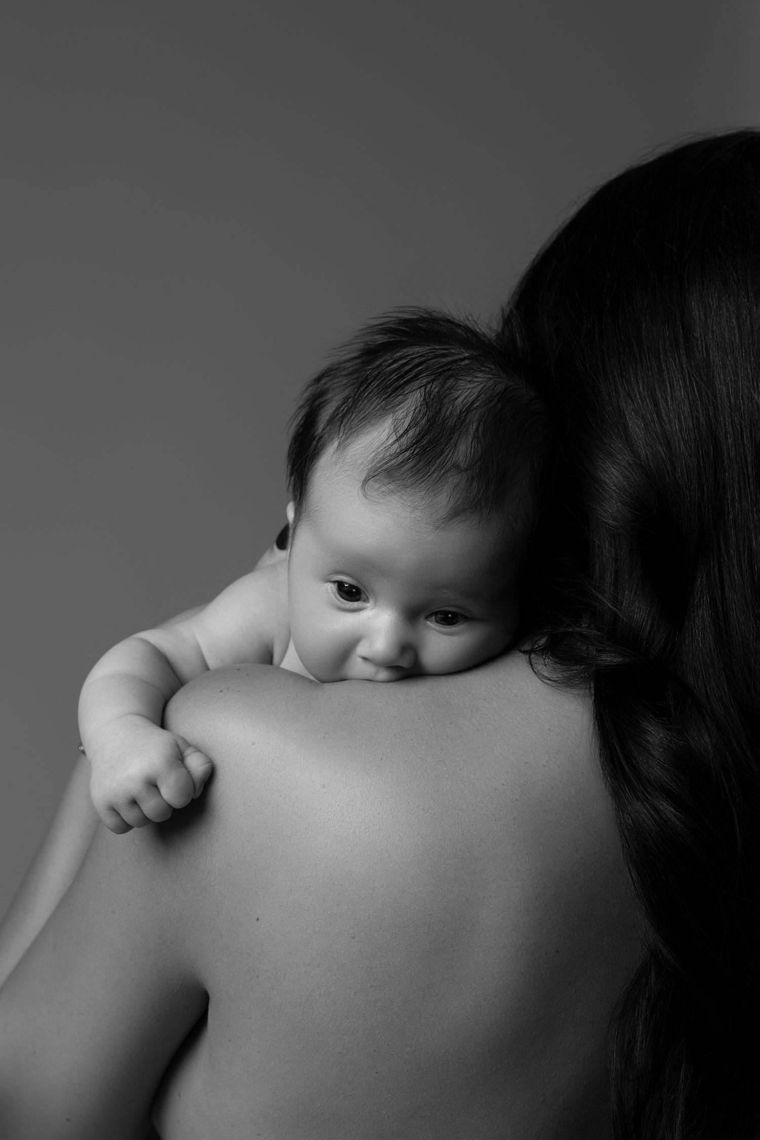 Delicate black and white newborn Mommy and Me portraits in Chicago, featuring a mother and her newborn in a natural and artistic pose.