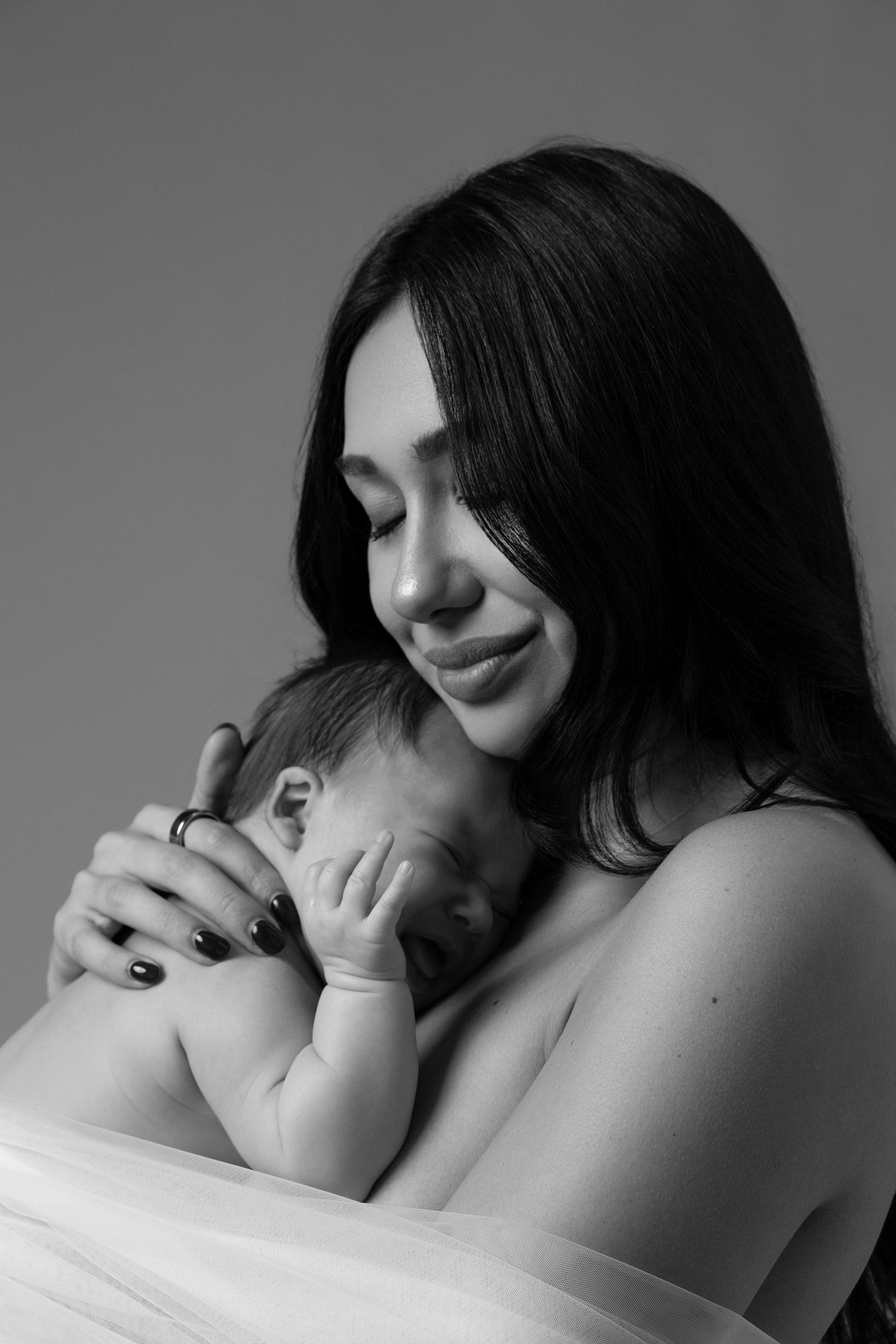 Tender black and white Mommy and Me newborn photoshoot in a Chicago studio, capturing soft and intimate moments between mother and baby.