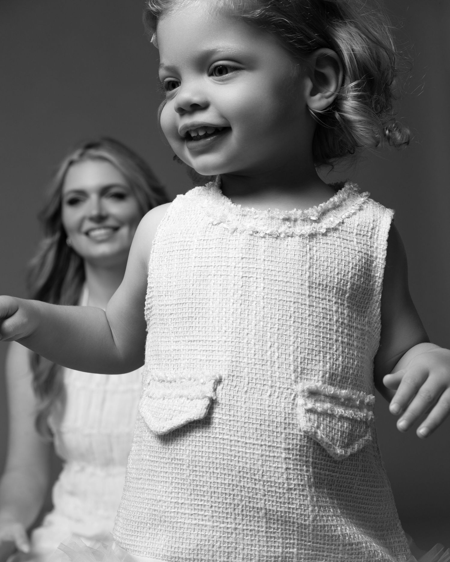 Black and white portrait of a Little 2 years old girl posing in dress in in a Chicago studio during a mommy and me professional photoshoot.
