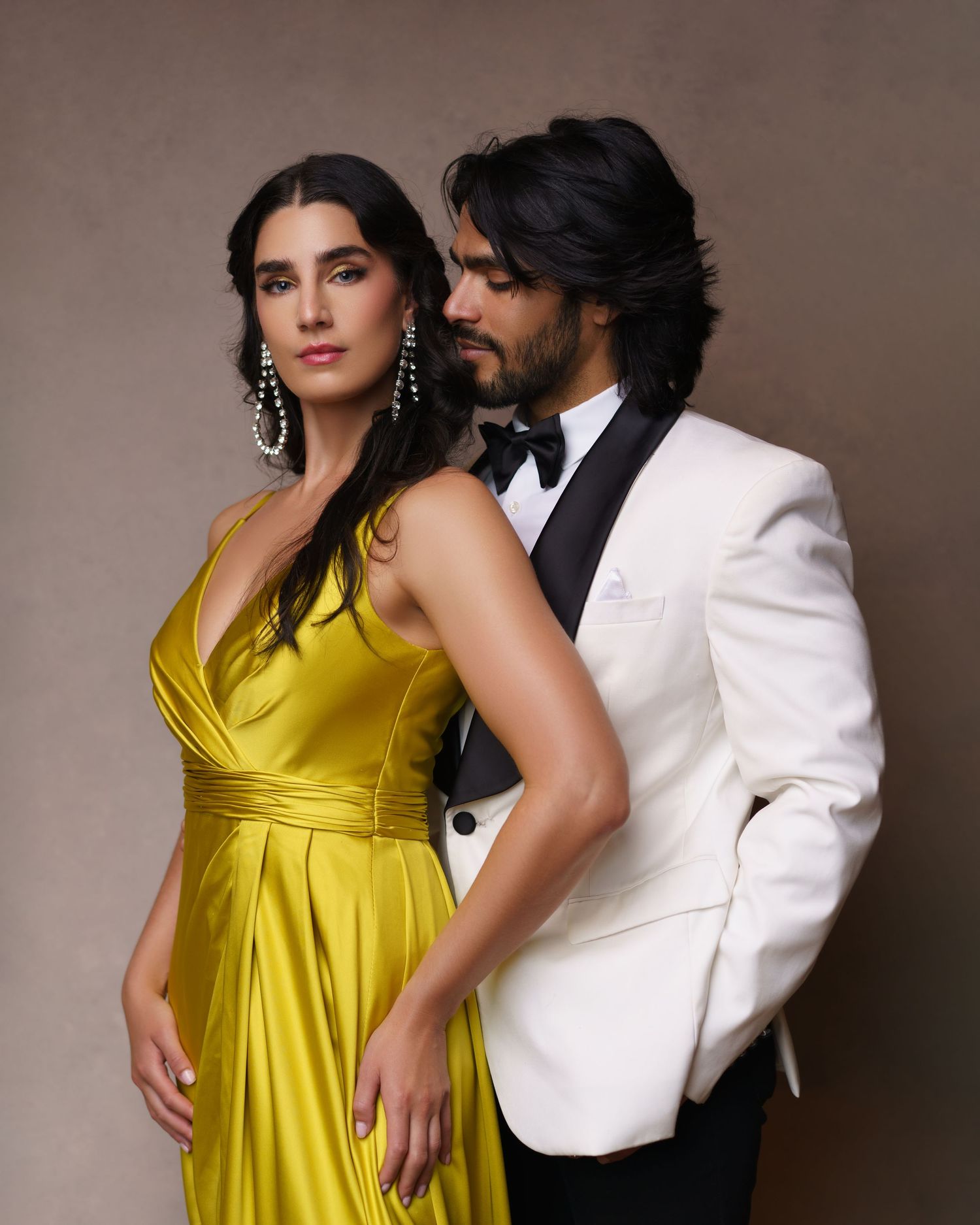 Stylish couple posing in a tuxedo and luxurious evening gown — a romantic couple’s love story captured in studio in Chicago.