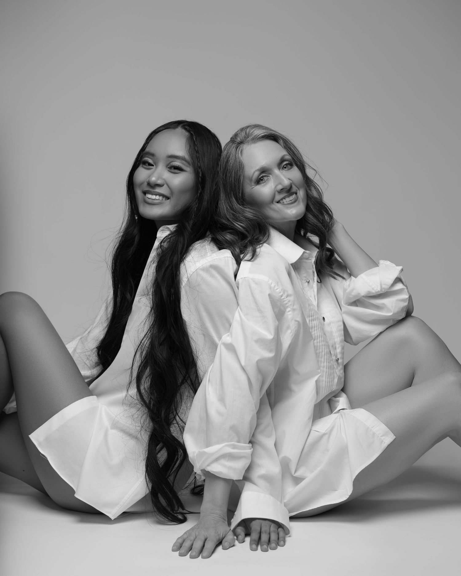 Mother and daughter posing in matching white shirts during studio photoshoot in Chicago — a beautiful celebration of two generation.