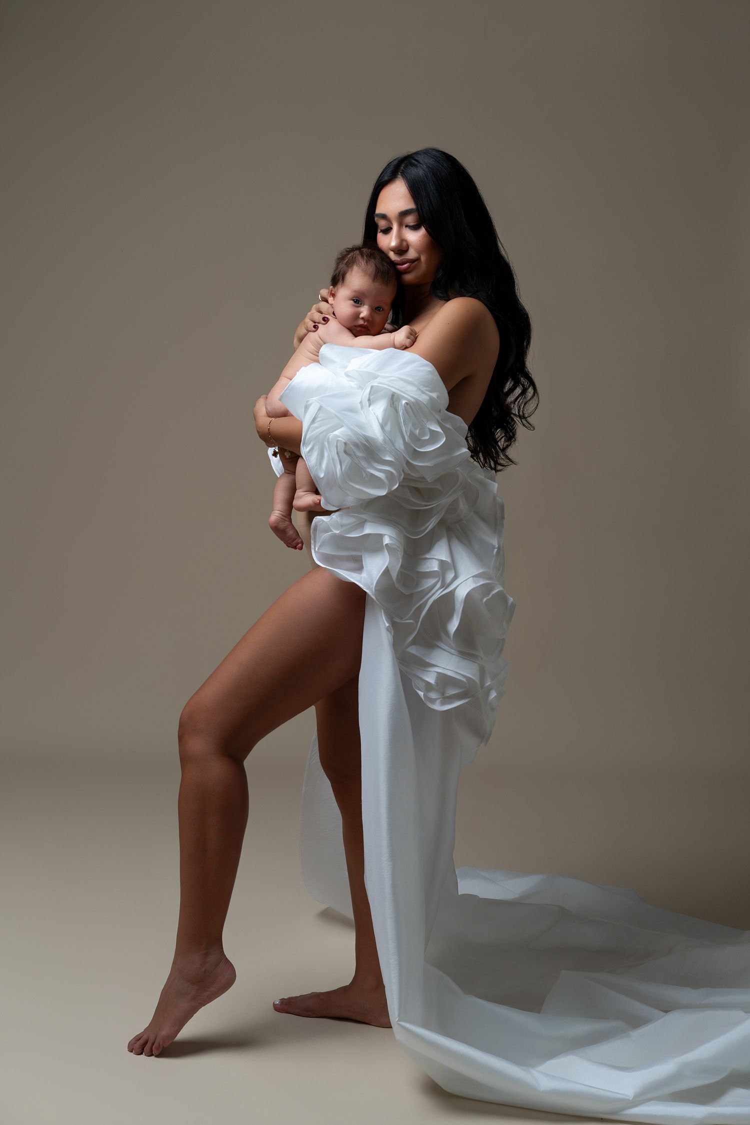 Elegant Mommy and Me studio portrait in Chicago with a mother in a luxury white cape adorned with flowers and her newborn baby.