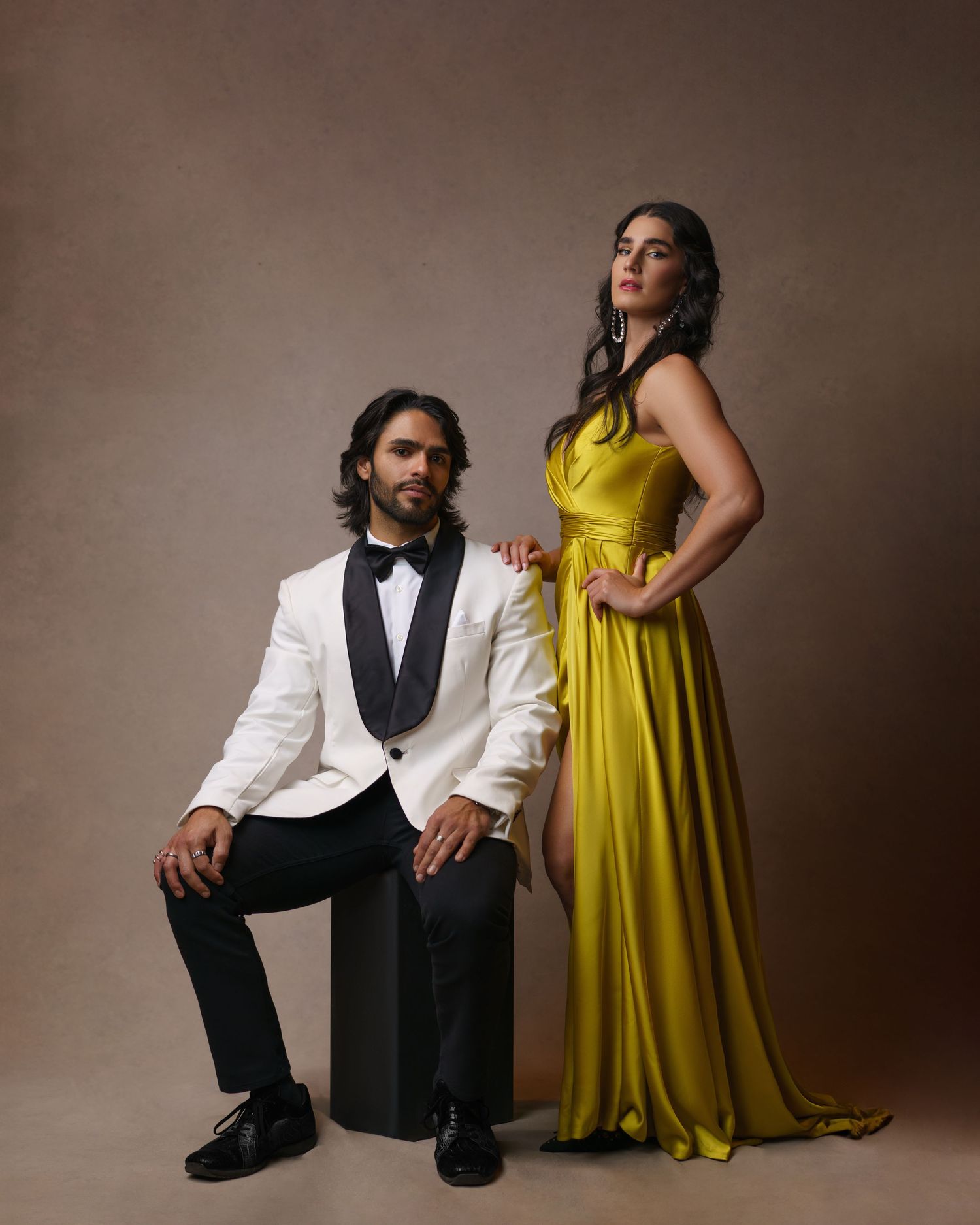 Stylish couple posing in a tuxedo and luxurious evening gown — a romantic couple’s love story captured in studio in Chicago.