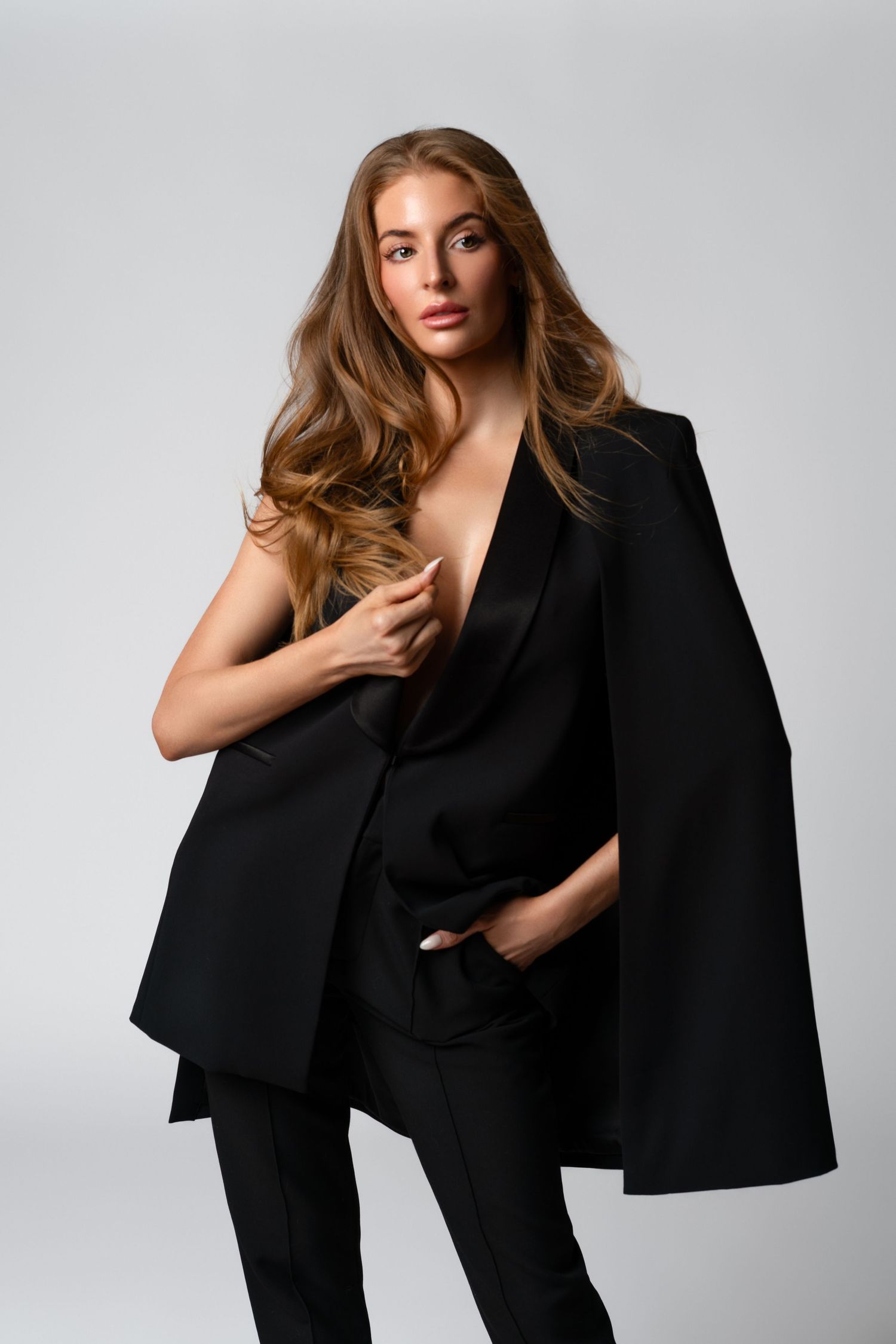 Woman posing in a black suit during her professional headshot photoshoot in Chicago. Sexy business portrait photoshoot in Chicago.