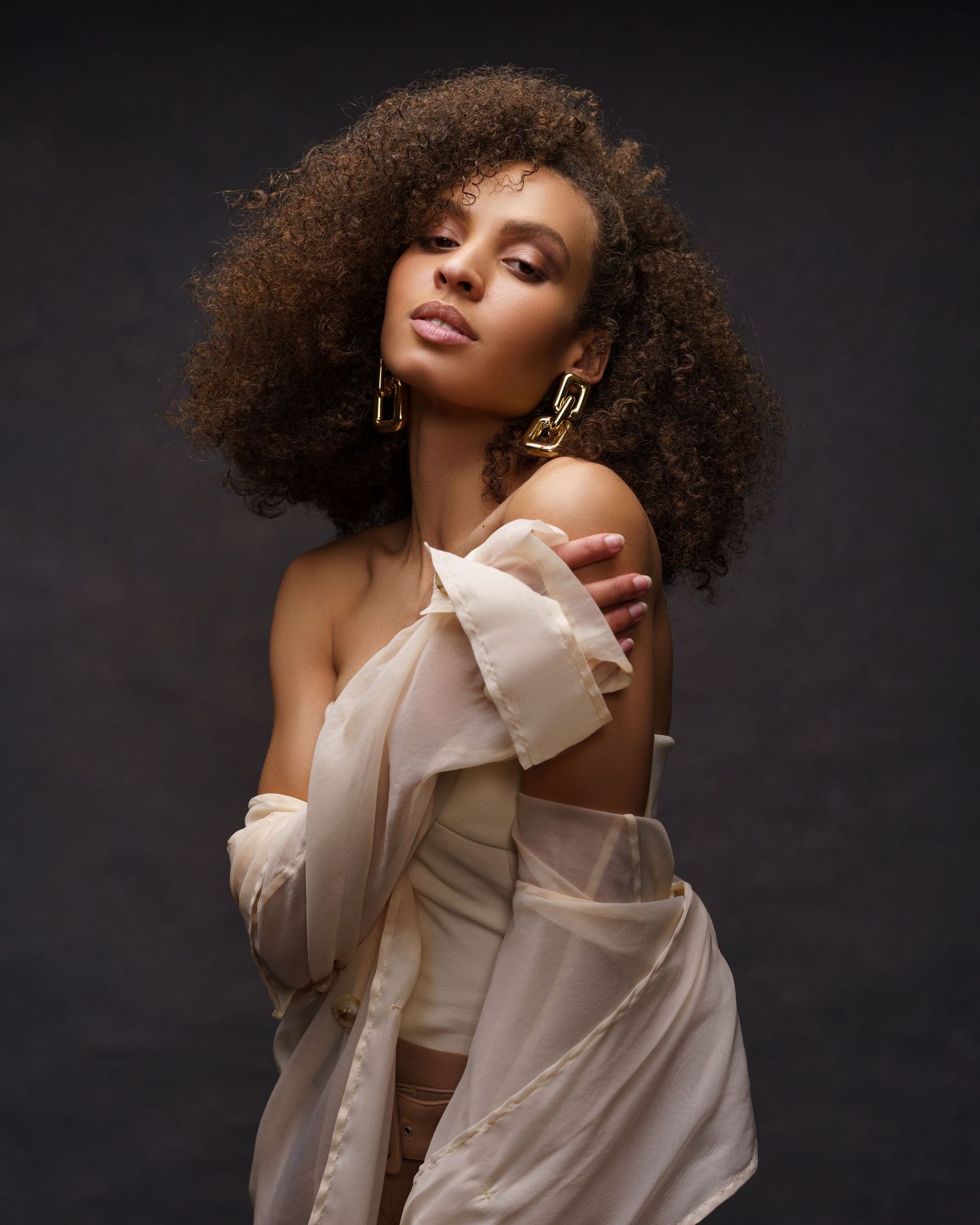 Young African American woman with curly hair posing for a glamorous fashion photoshoot in Chicago — confident, relaxed, and radiant.