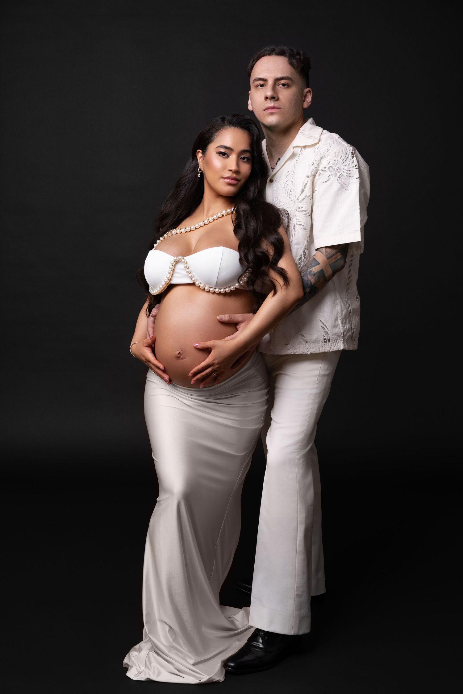 Luxury maternity photoshoot in a Chicago studio — stylish couple in matching white outfits celebrating this special moment.
