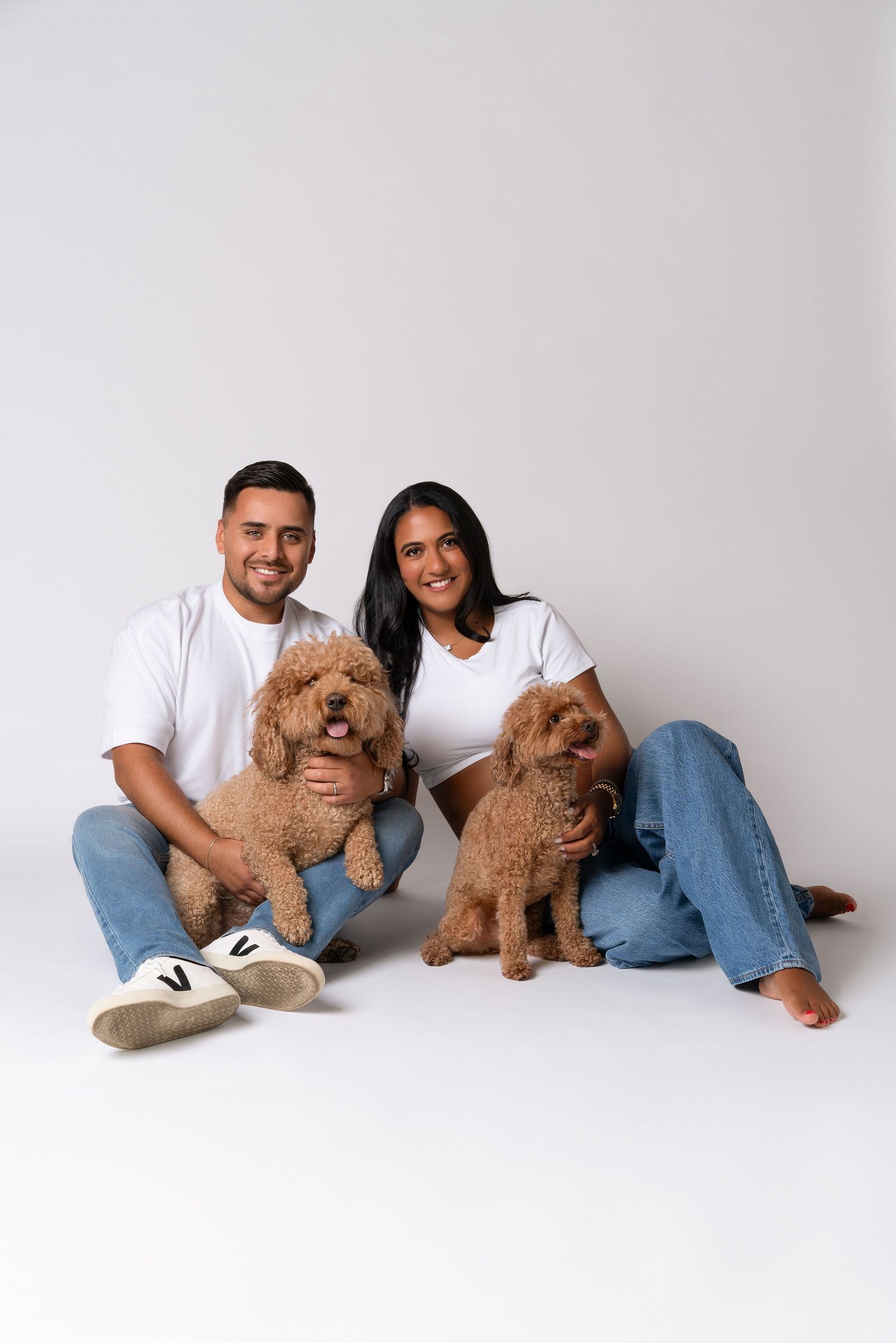 Maternity couple photoshoot with dogs in Chicago studio of maternity photographer — couple in jeans and white t-shirts with two dogs.
