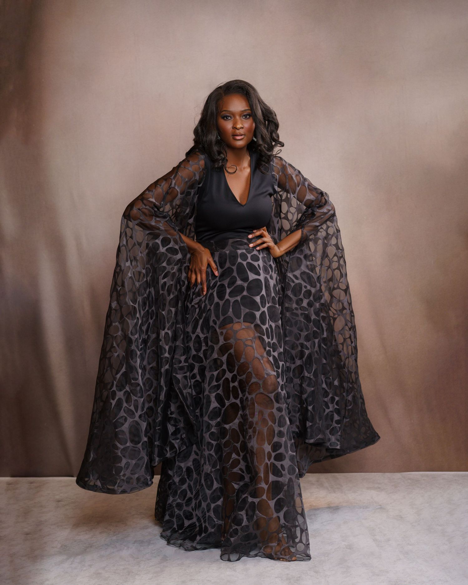 Gorgeous African American woman with voluminous curly hair posing in a leopard couture dress — glamorous studio portrait in Chicago.