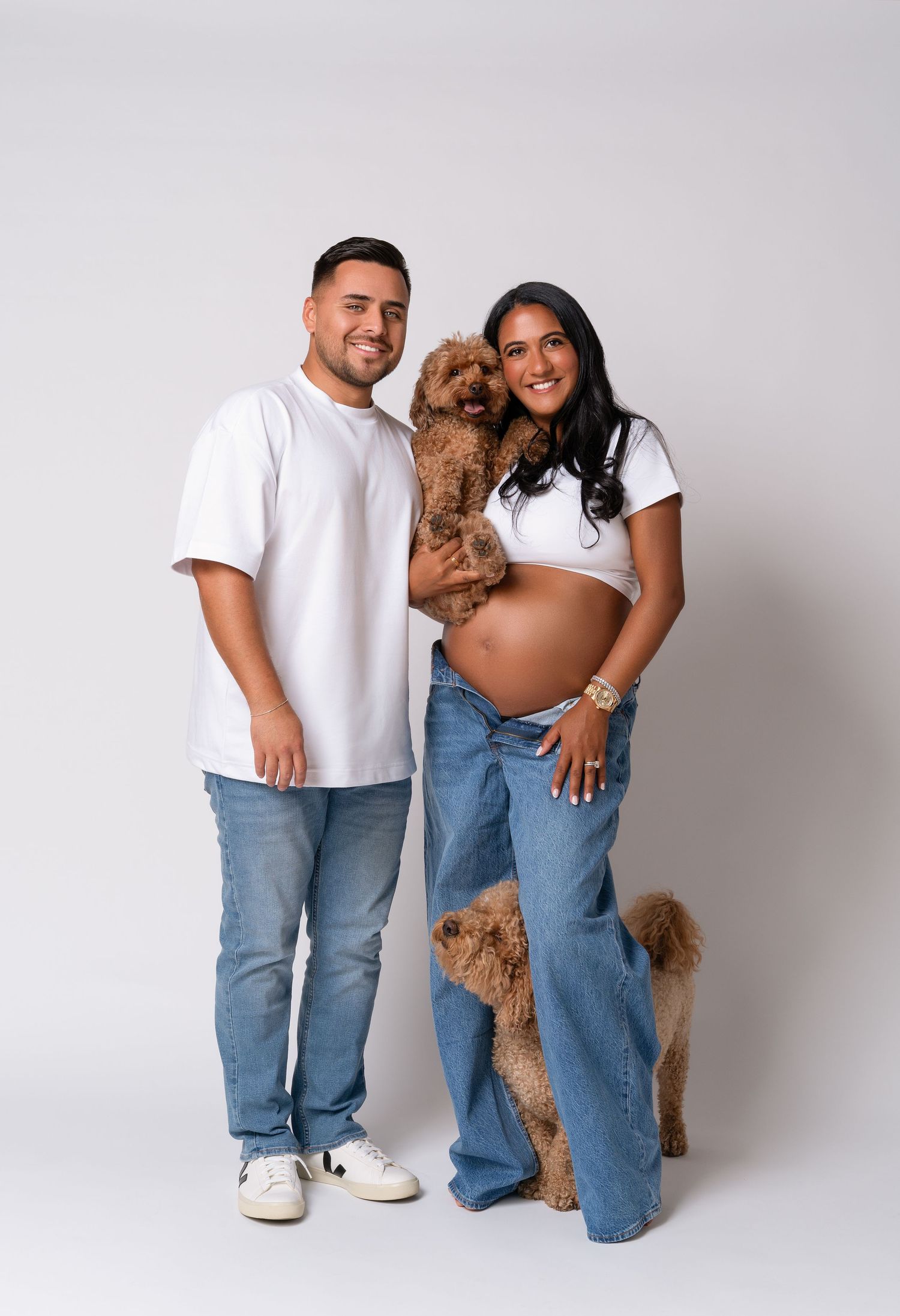 Maternity couple photoshoot with dogs in Chicago studio of maternity photographer — couple in jeans and white t-shirts with two dogs.
