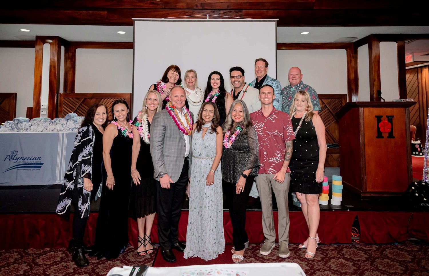Group of professionals posing together at a formal banquet event in an elegant wood-paneled venue.