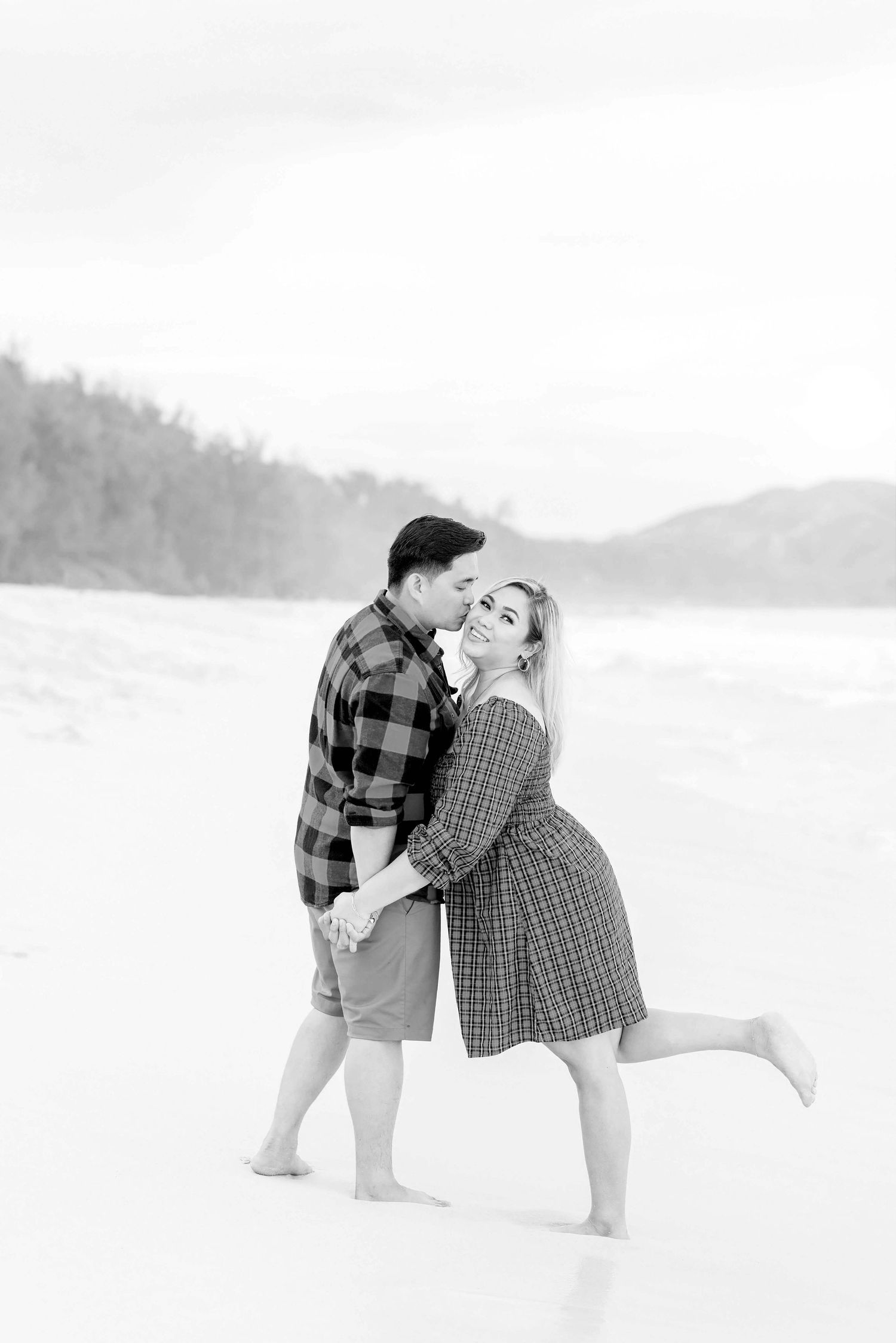 A couple in plaid shirts poses playfully in a sequence of black and white photos against a snowy landscape.