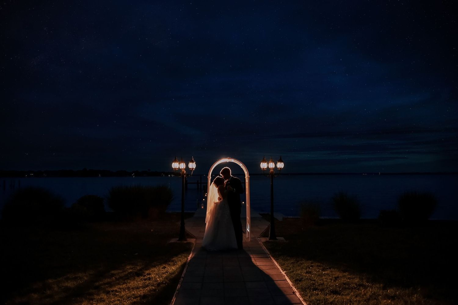 A series of moody nighttime photos showing silhouettes of lampposts against dark, twilit skies.