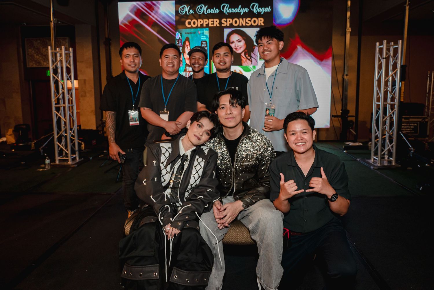 Group of people posing together at a Copper Sponsor event backdrop, smiling for a formal group photo.