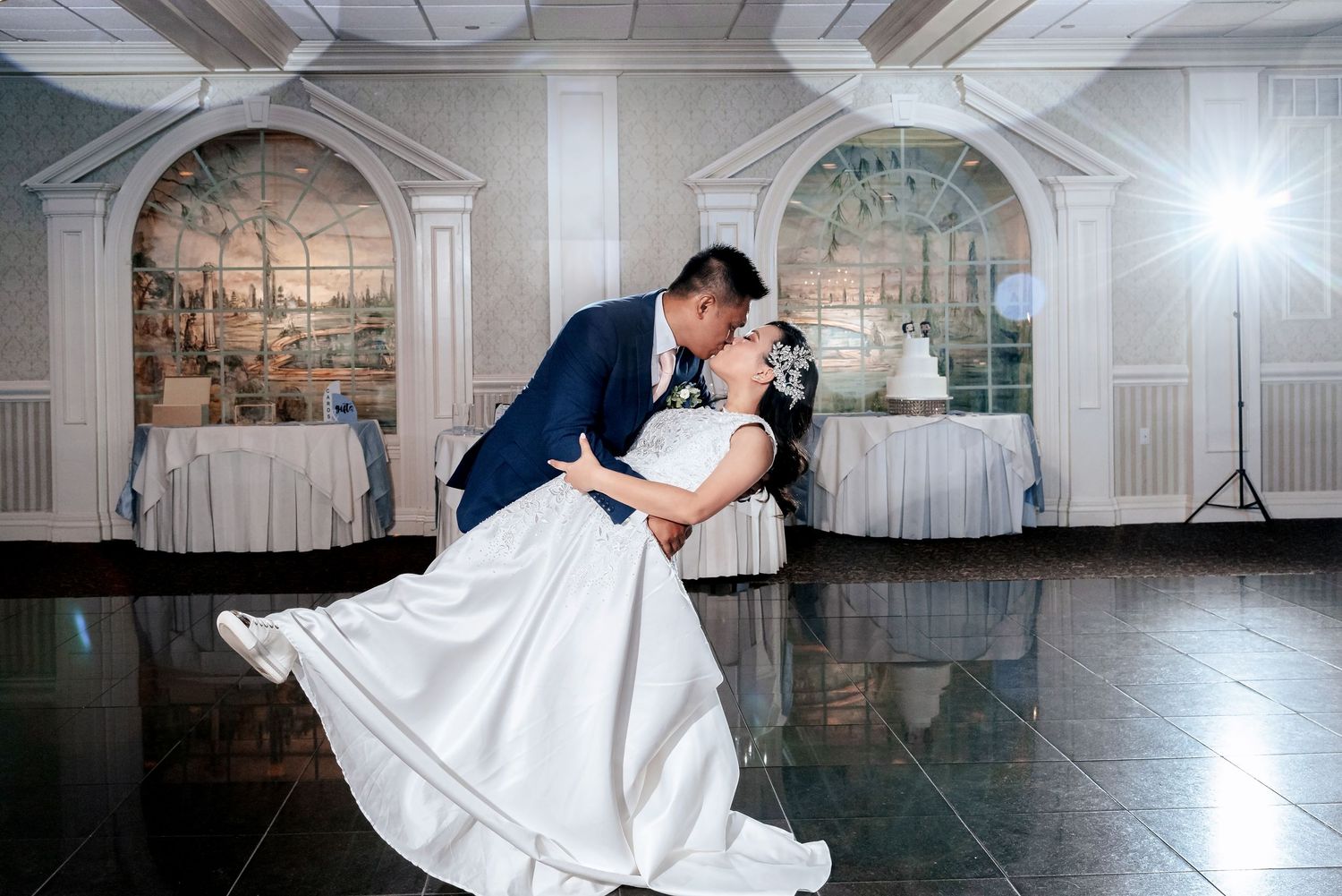 Classic black and white wedding photos captured in elegant ballroom setting with grand architectural details.