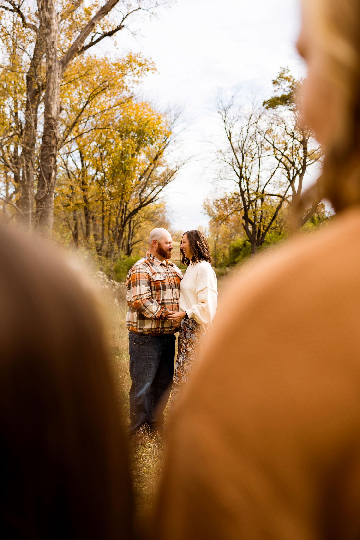 Autumn trees with golden leaves frame a peaceful gathering in a natural outdoor setting.