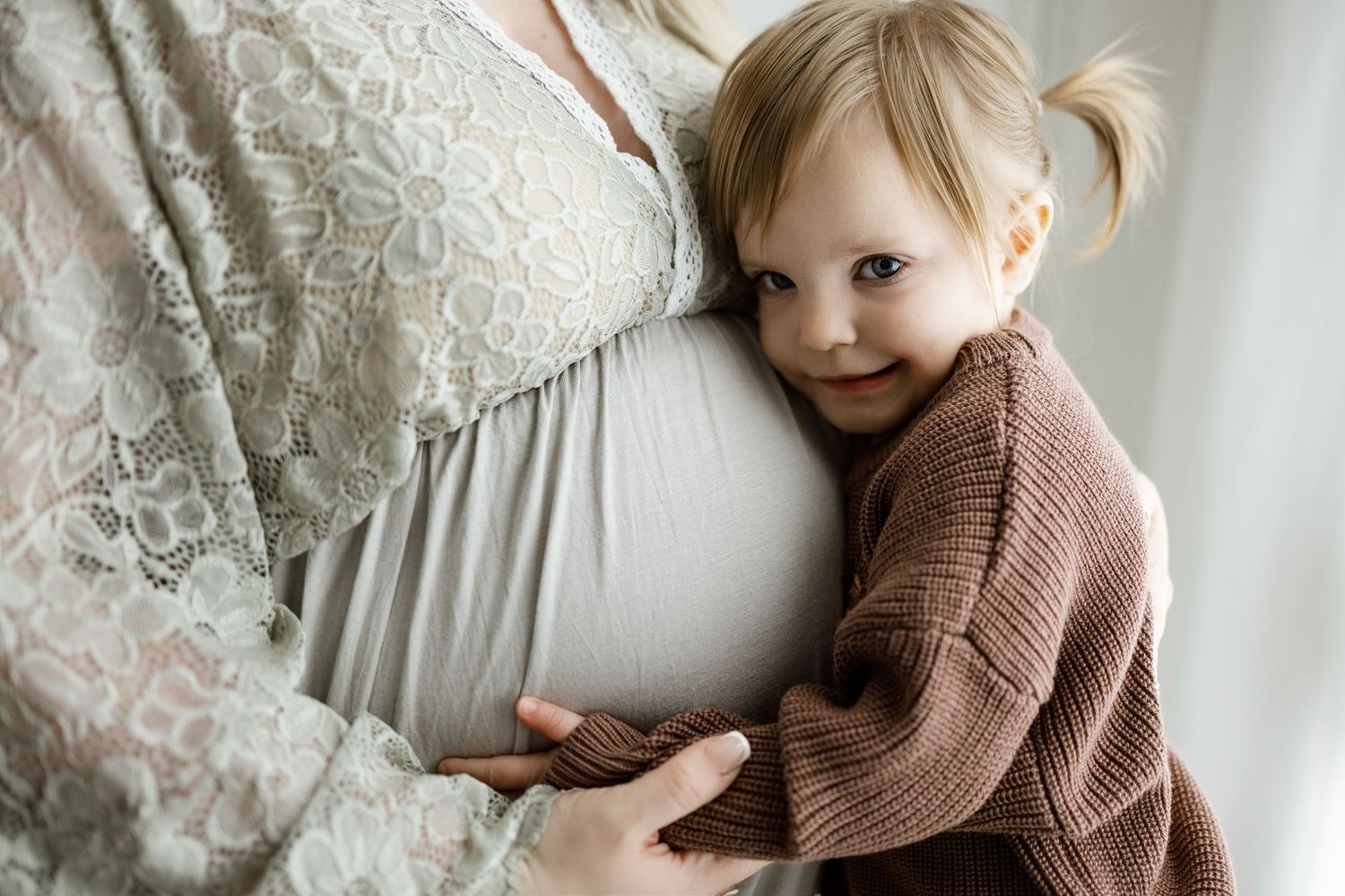 A collection of soft, dreamy photos featuring a toddler in a knit sweater against a white backdrop.