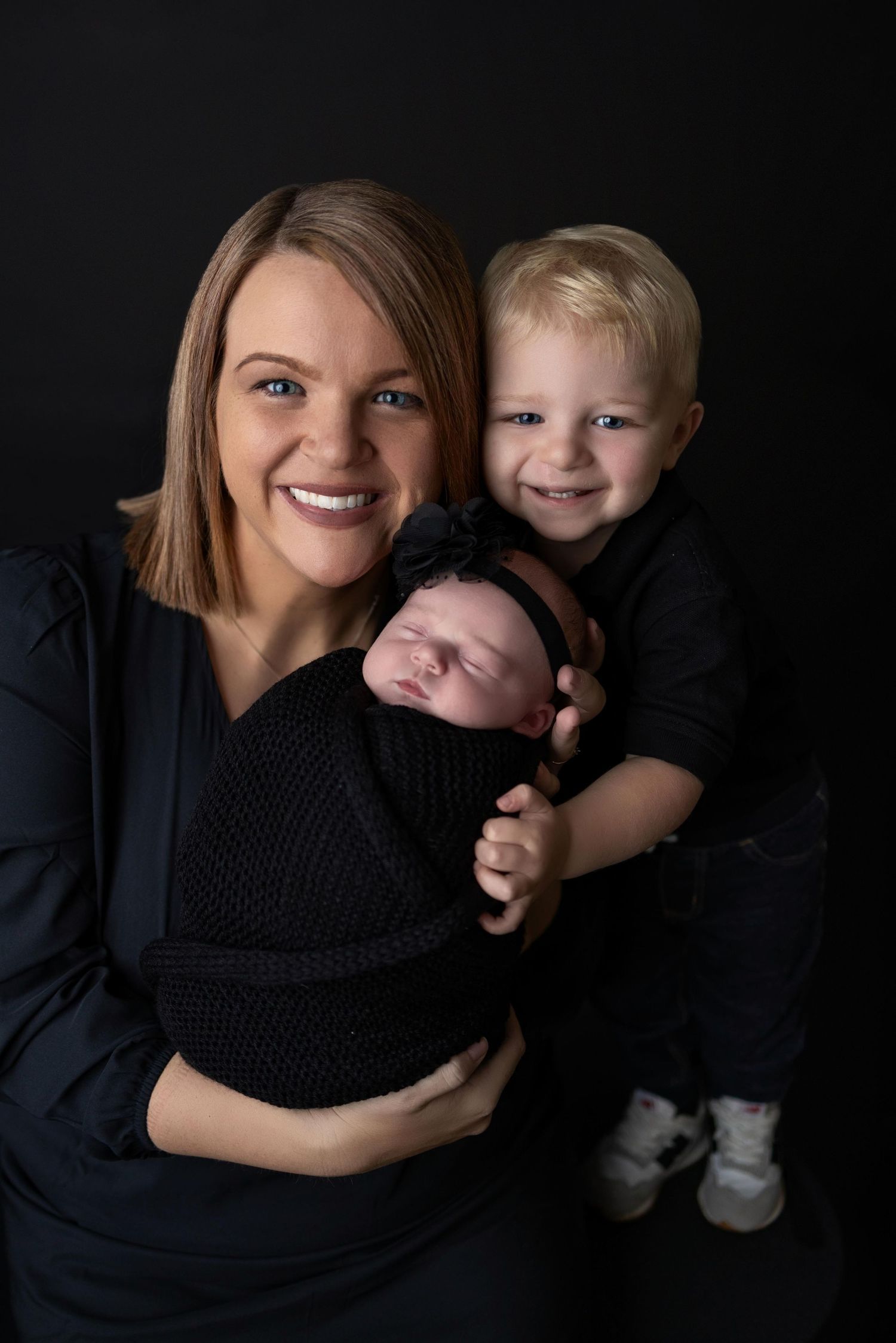A series of intimate black and white family portraits showing tender moments against a dark background.