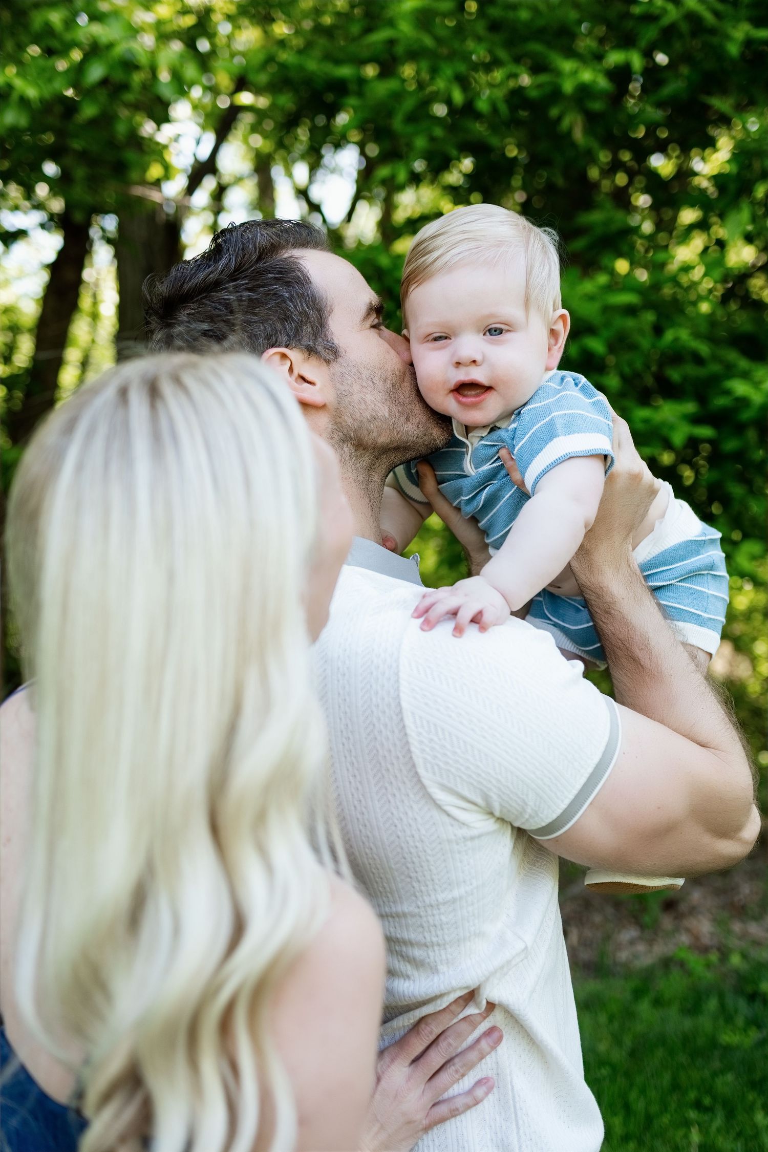 Parents sharing a sweet moment with their baby during an outdoor family photography session in the Edwardsville area