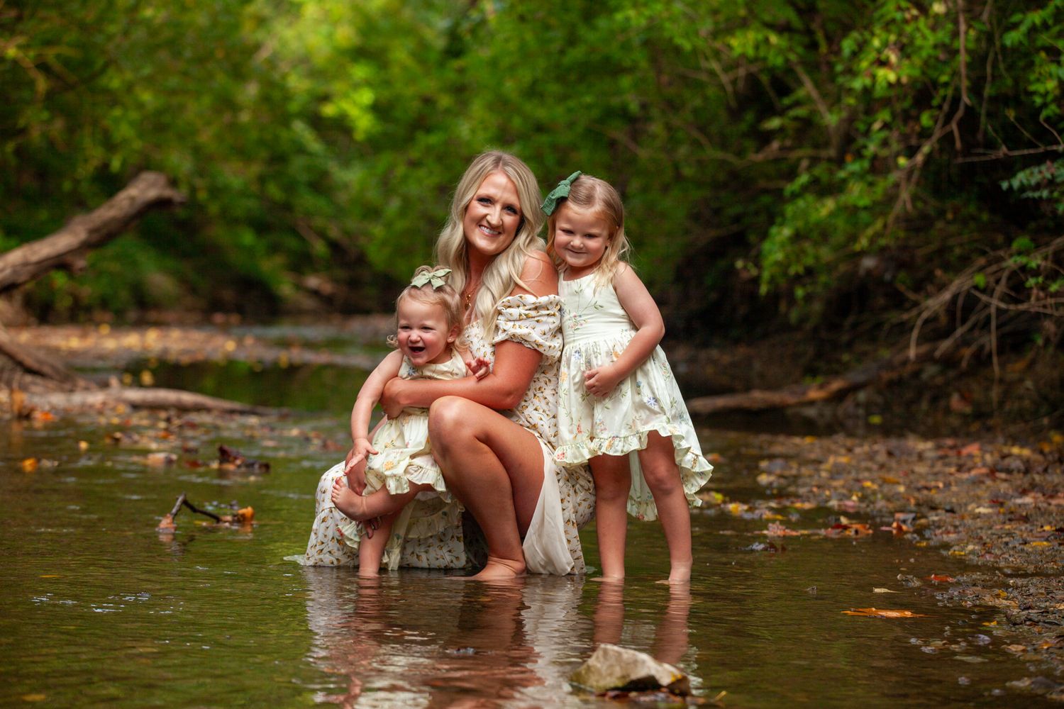 A heartwarming scene of a family enjoying time together at a shallow creek surrounded by lush greenery.