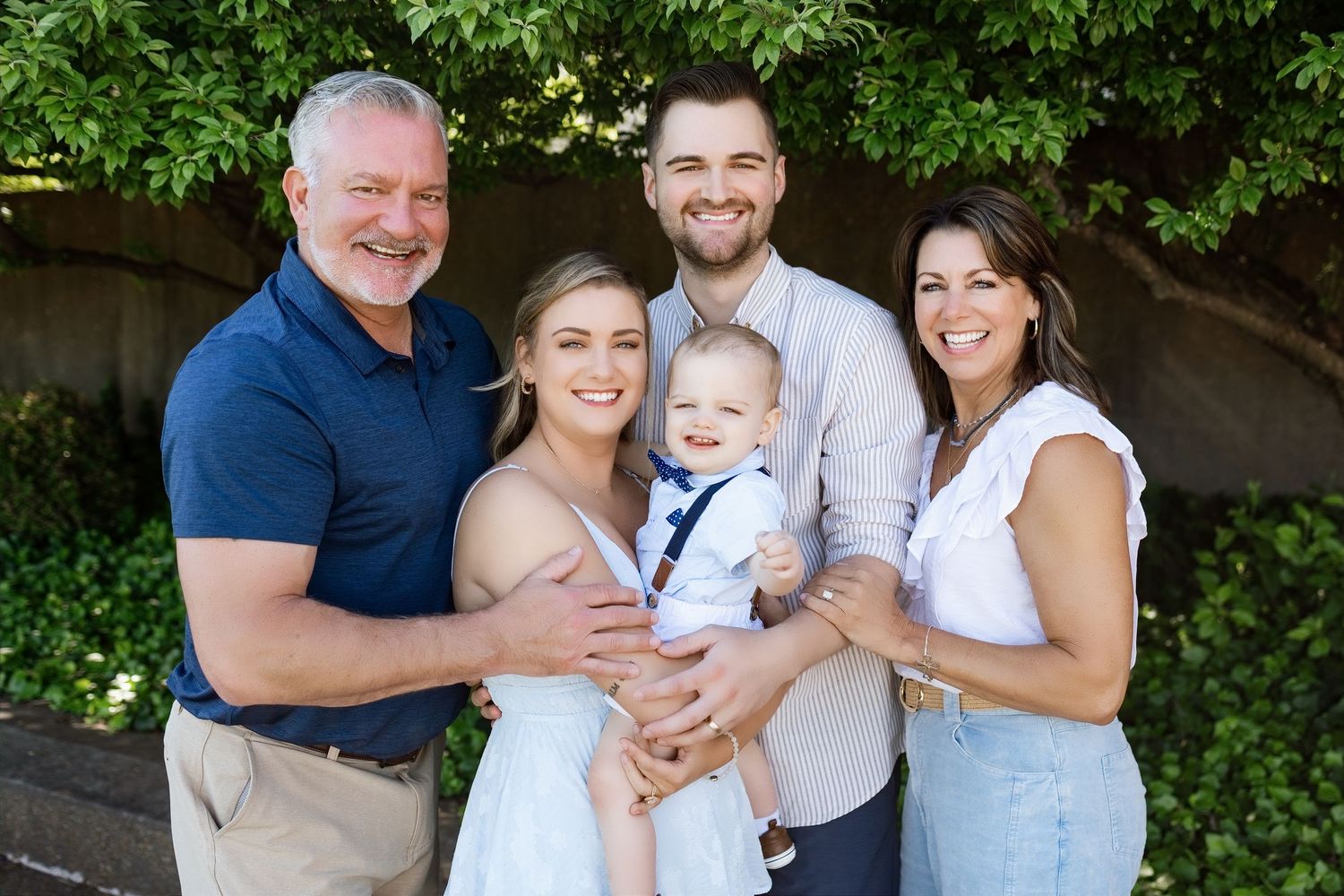 Family of five with a baby smiling together during an outdoor extended-family photography session near Edwardsville