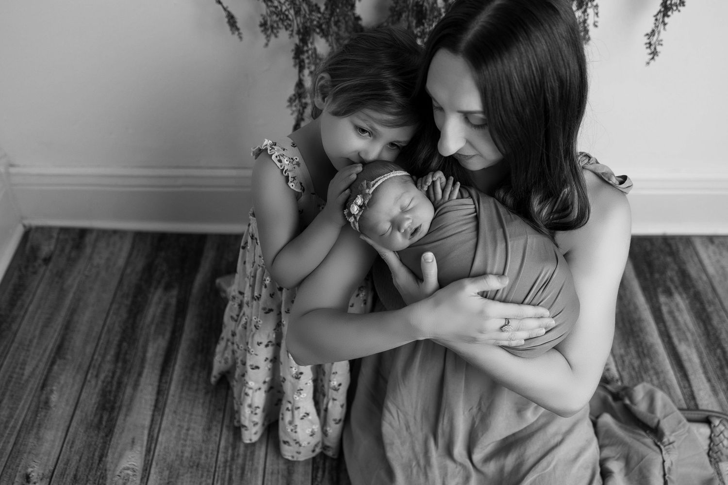 A black and white photo strip showing tender moments between a parent and child in various candid poses.