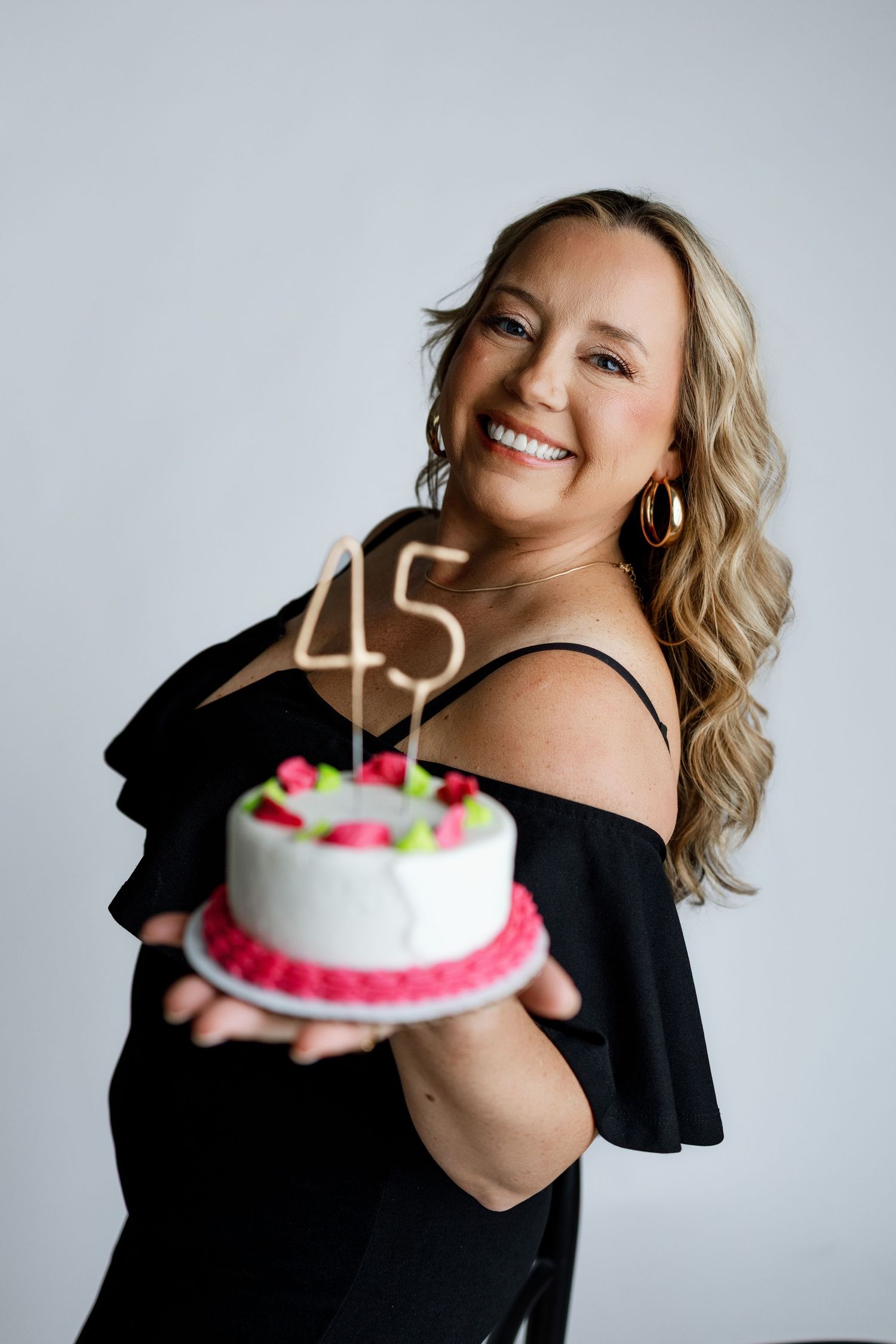 Woman celebrating her 45th birthday with a custom cake during a milestone studio photography session in Edwardsville
