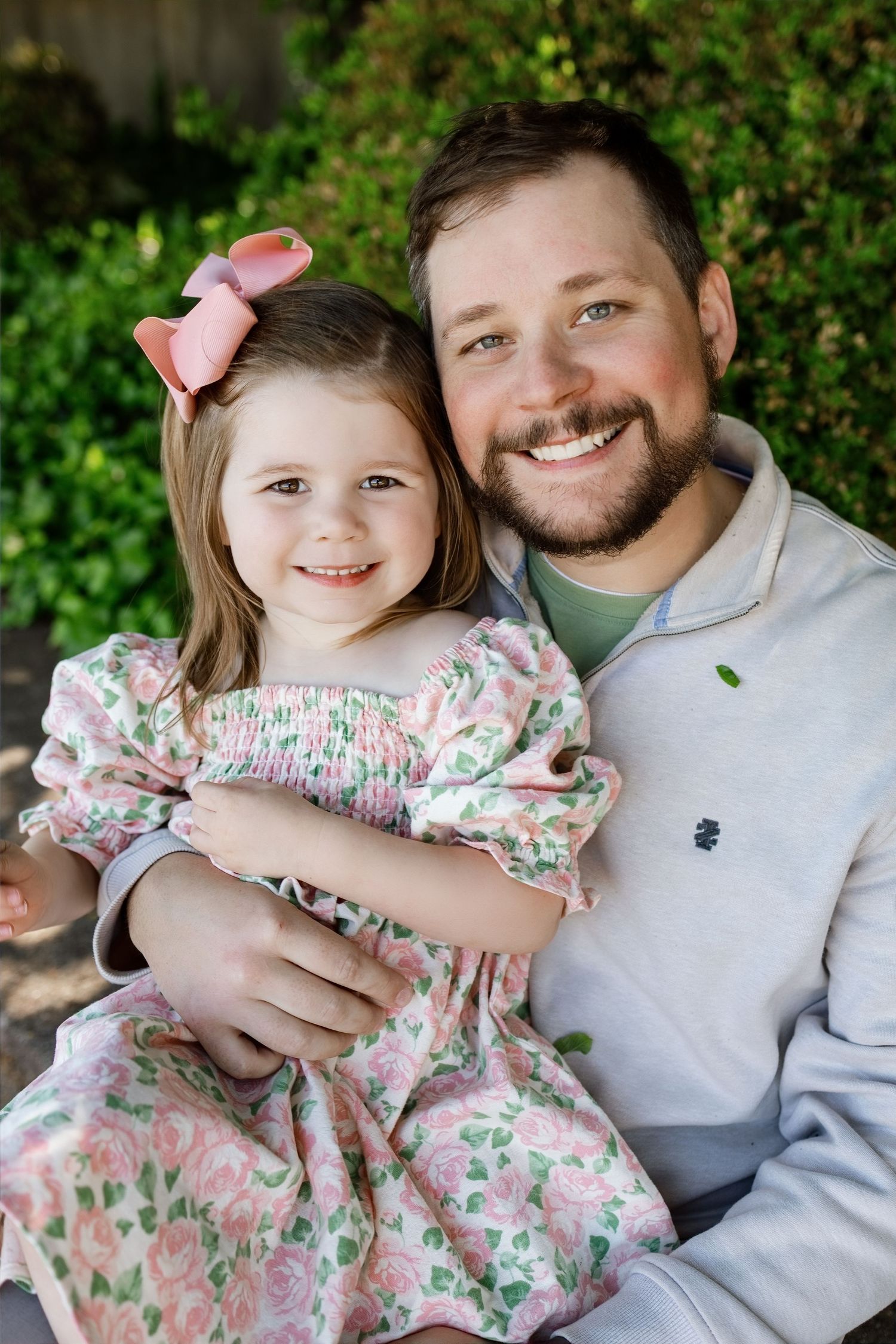 Father holding his young daughter during a candid outdoor family portrait in the Metro East area
