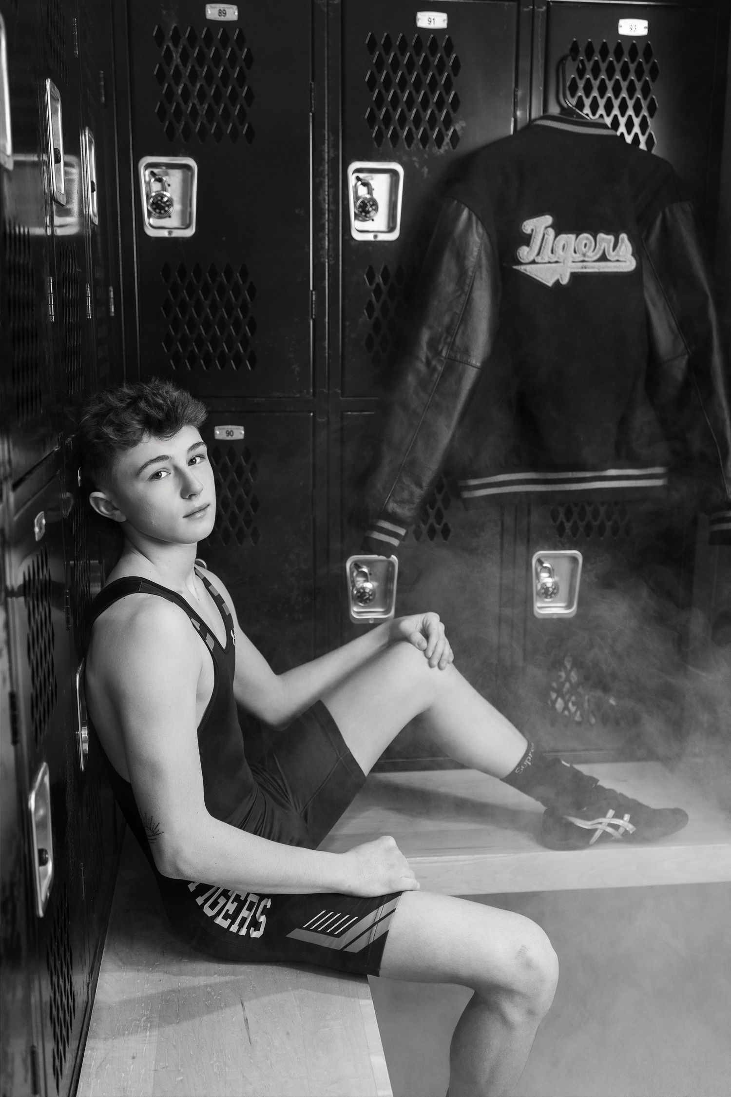 A black and white photo series showing someone writing or studying at a desk near school lockers.