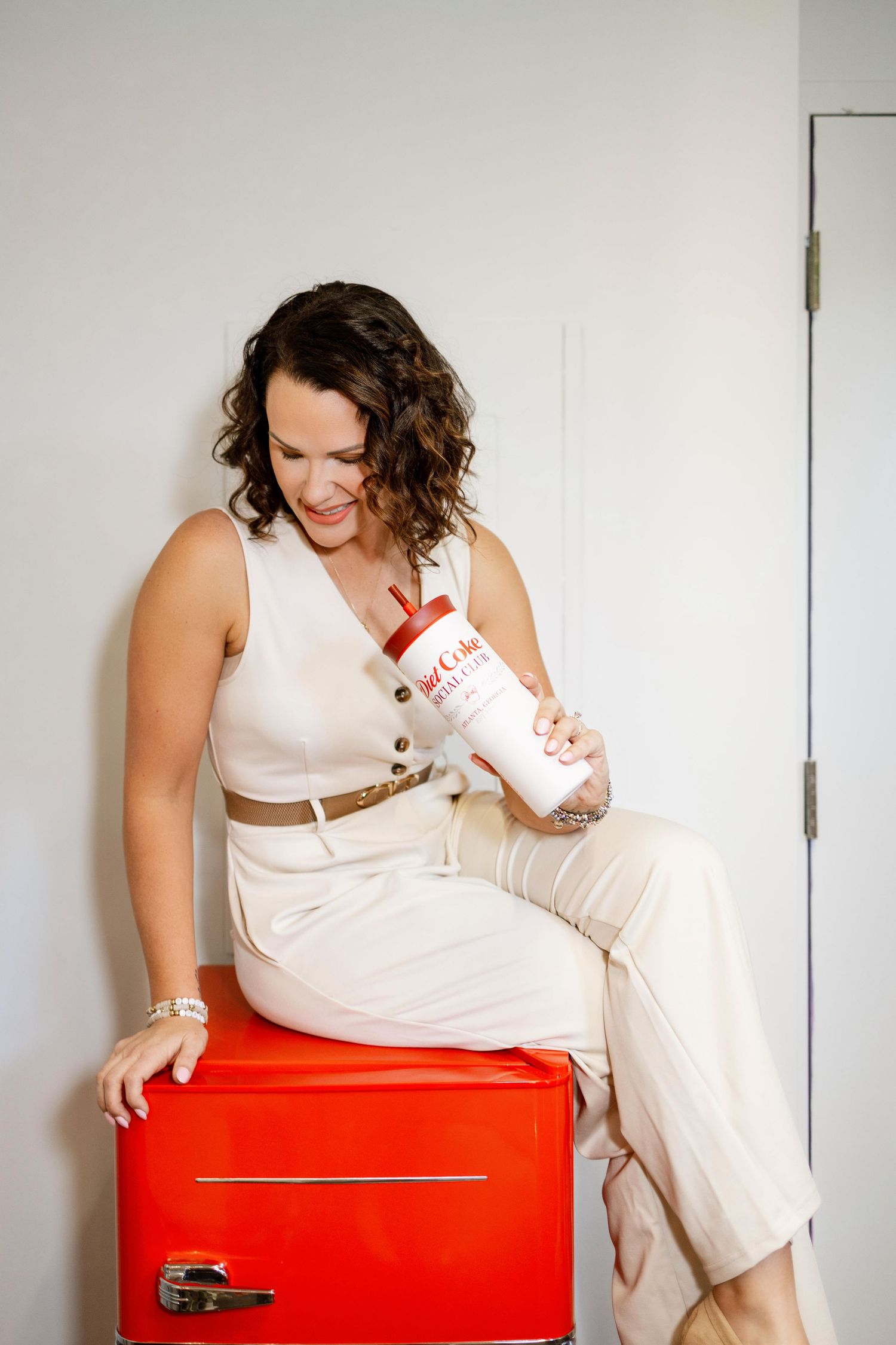 Lifestyle photoshoot featuring white outfit and red storage box in minimalist setting.