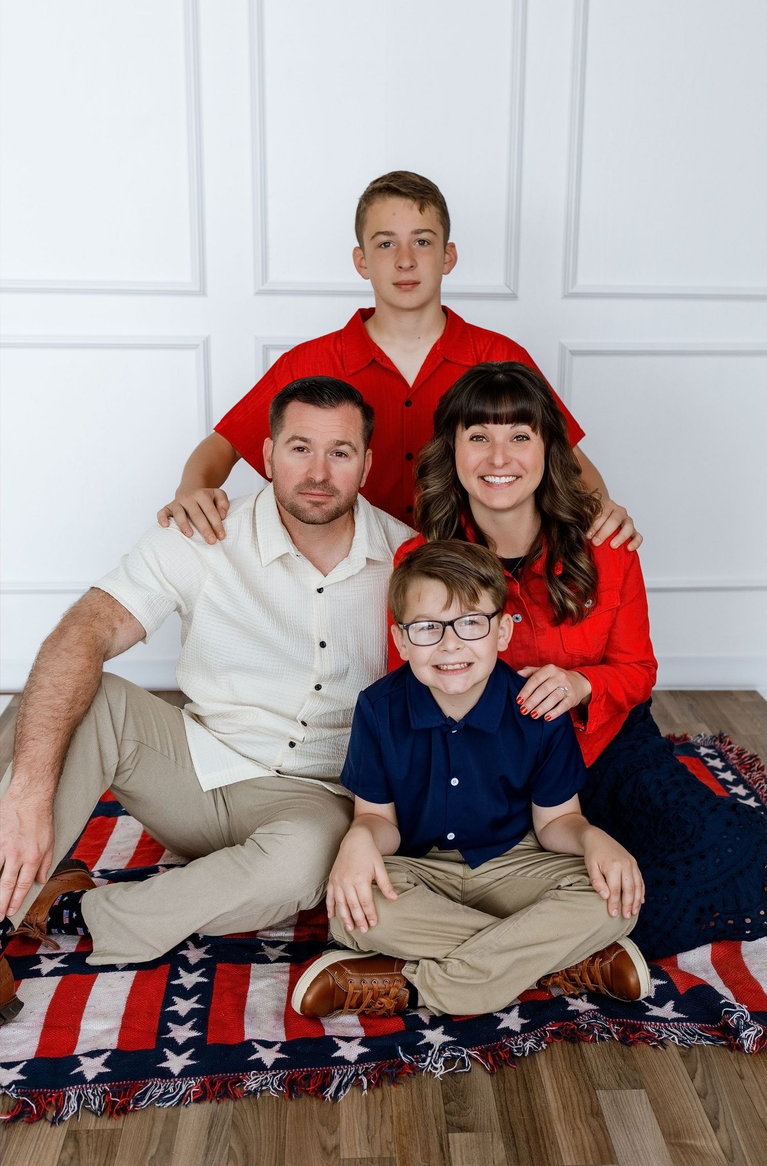 Parents and their two sons posing together during a patriotic family photography session at the TLP studio
