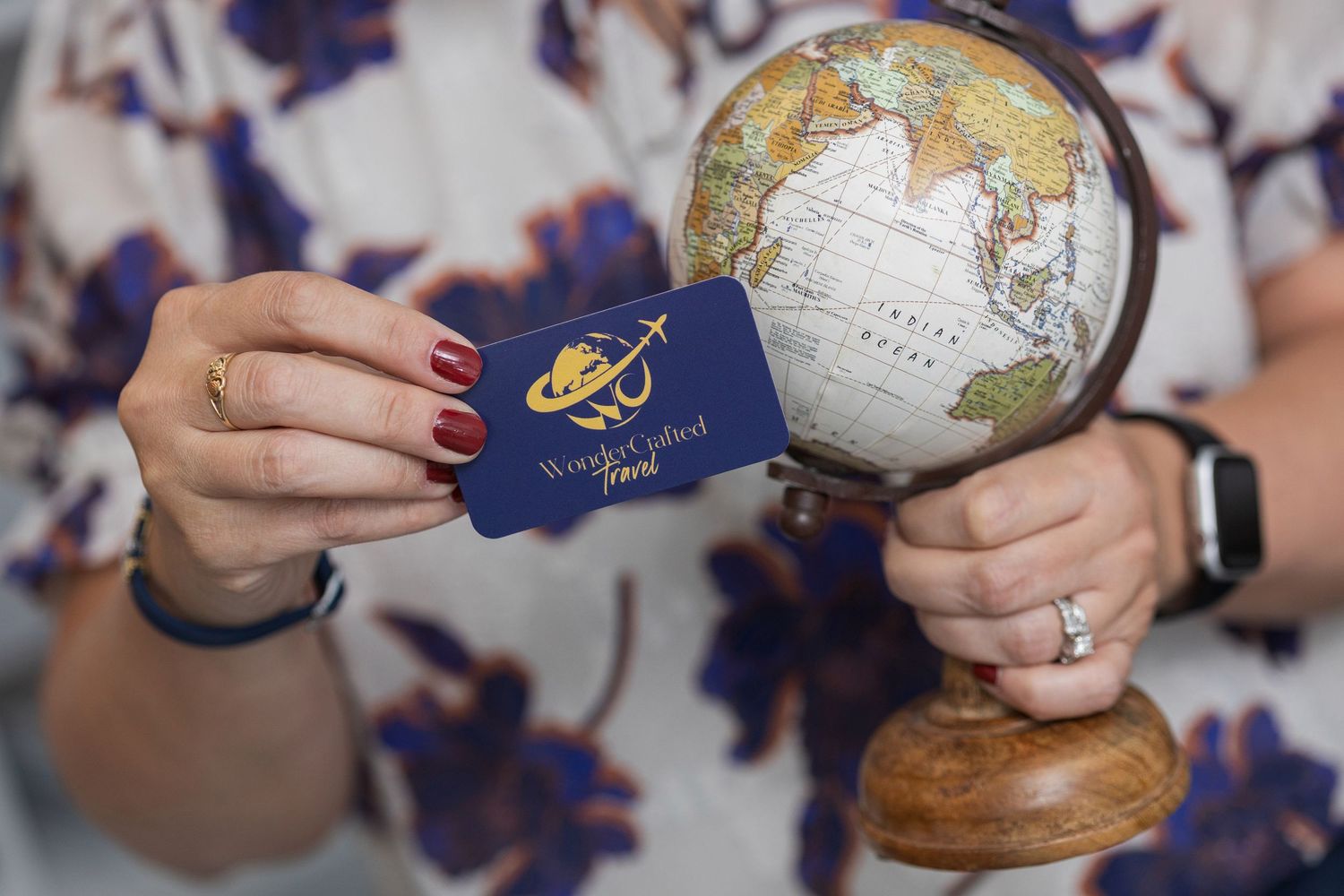 Passport and globe being held against a blurred blue background, symbolizing international travel and exploration.