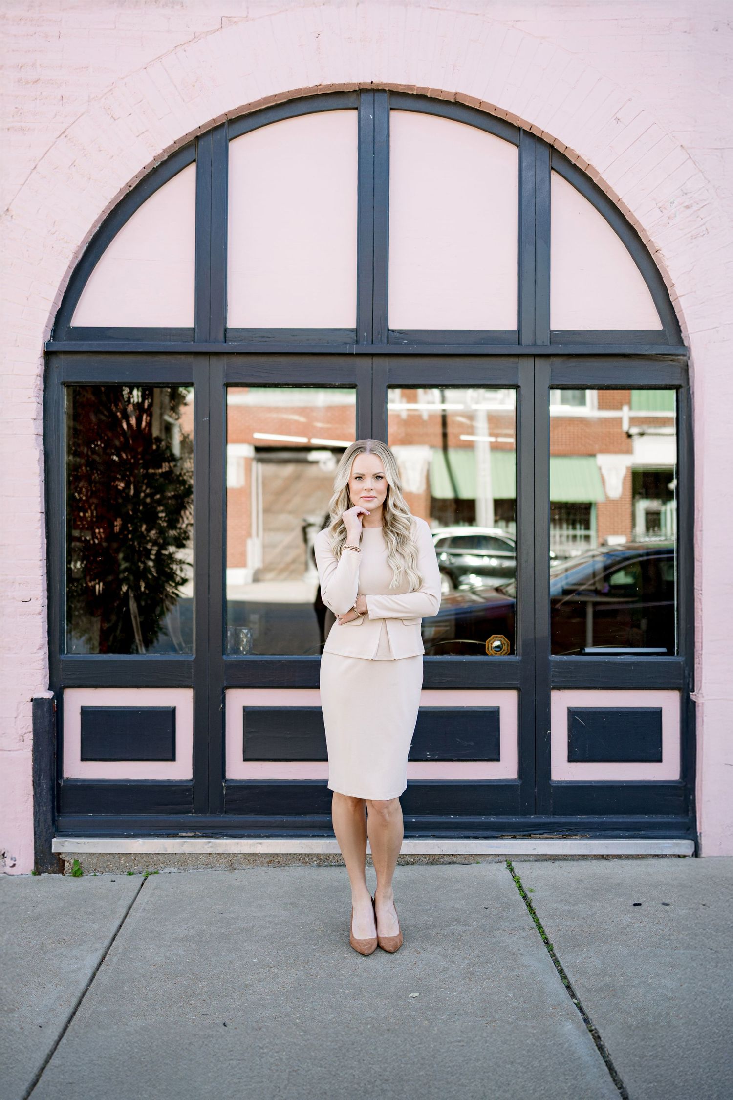 A triptych photo series showing someone in a white dress posing against a building facade with arched windows.