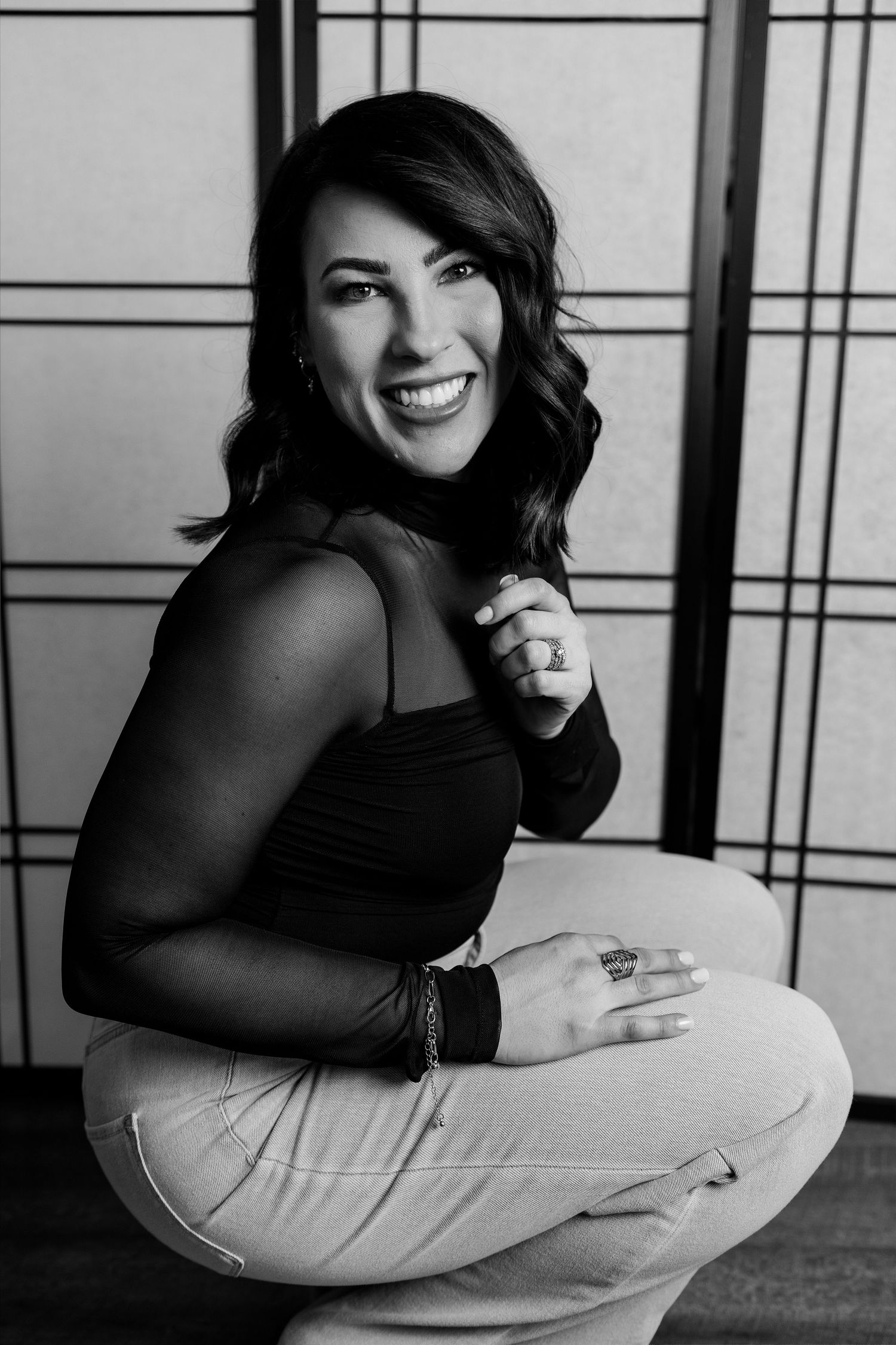 Black and white photo series showing person in casual attire posing with pillow against geometric patterned backdrop.