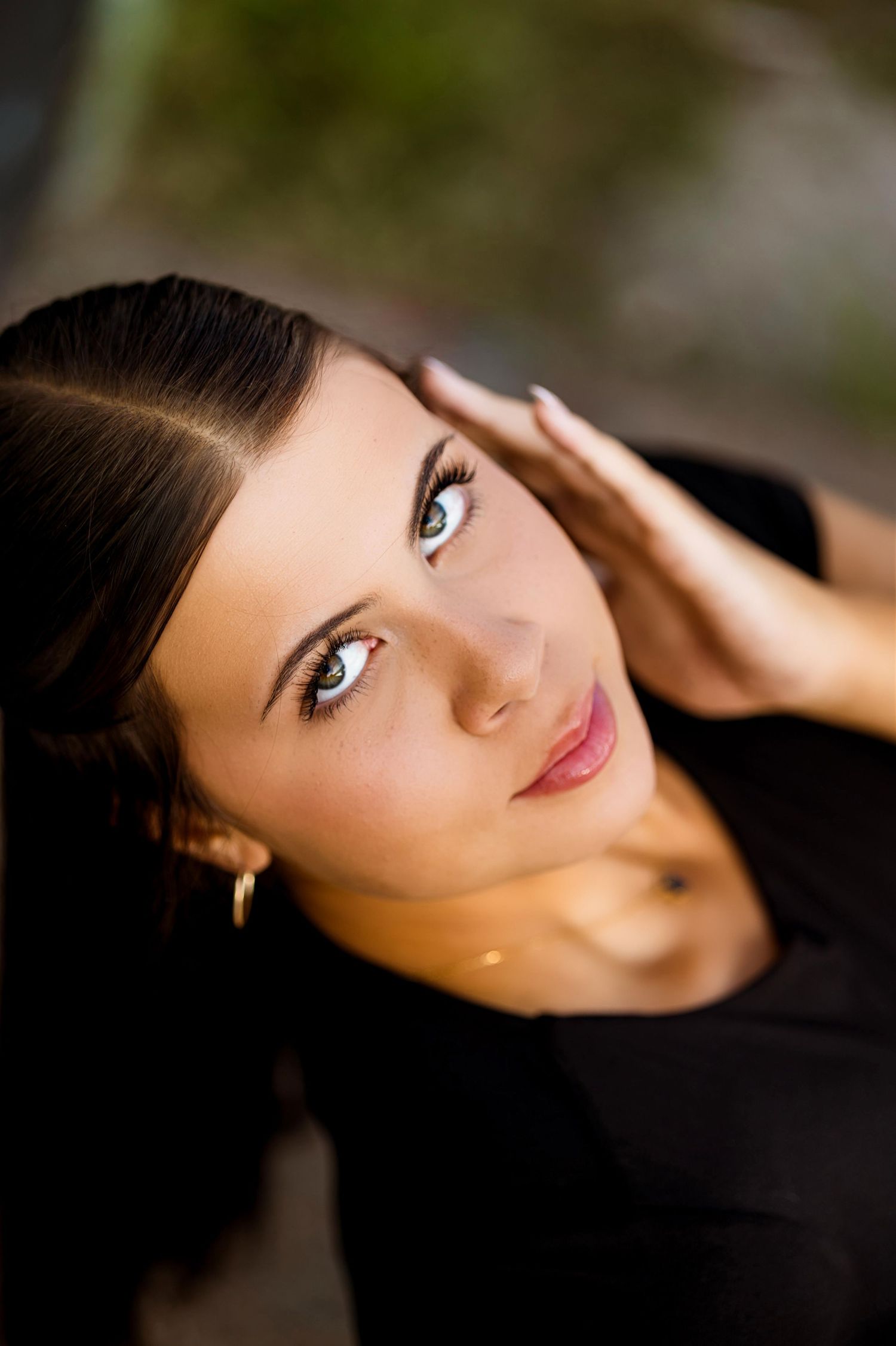 Close-up artistic portraits showcasing striking blue eyes and natural makeup against a dark background.